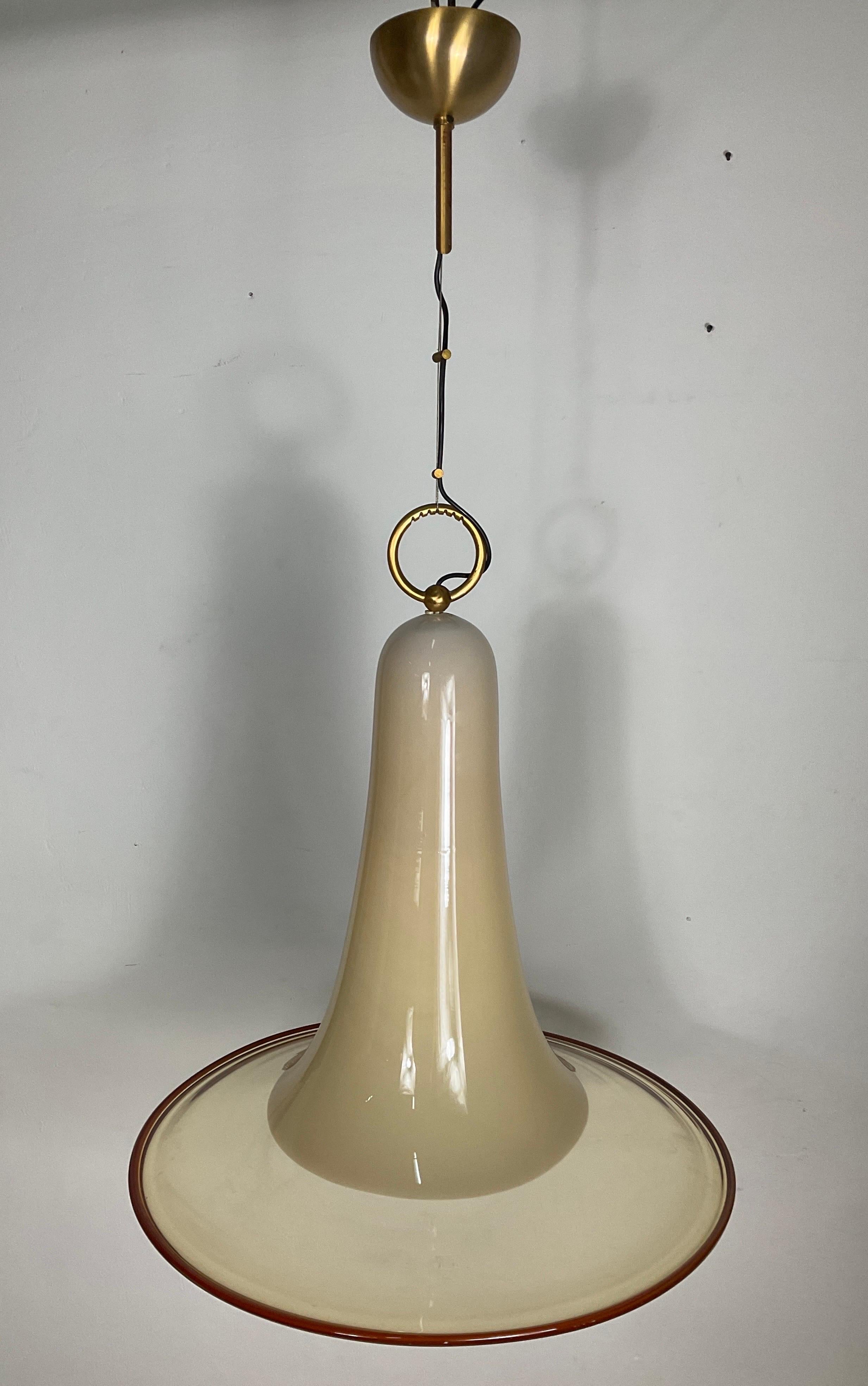 Outstanding Mid-Century Modern large pendant light fixture with stunning elongated bell formation. hand blown Murano glass in hues of parchment with amber glass rim. Features a stylized brass ring fitting with fabric coiled cord. Members of the