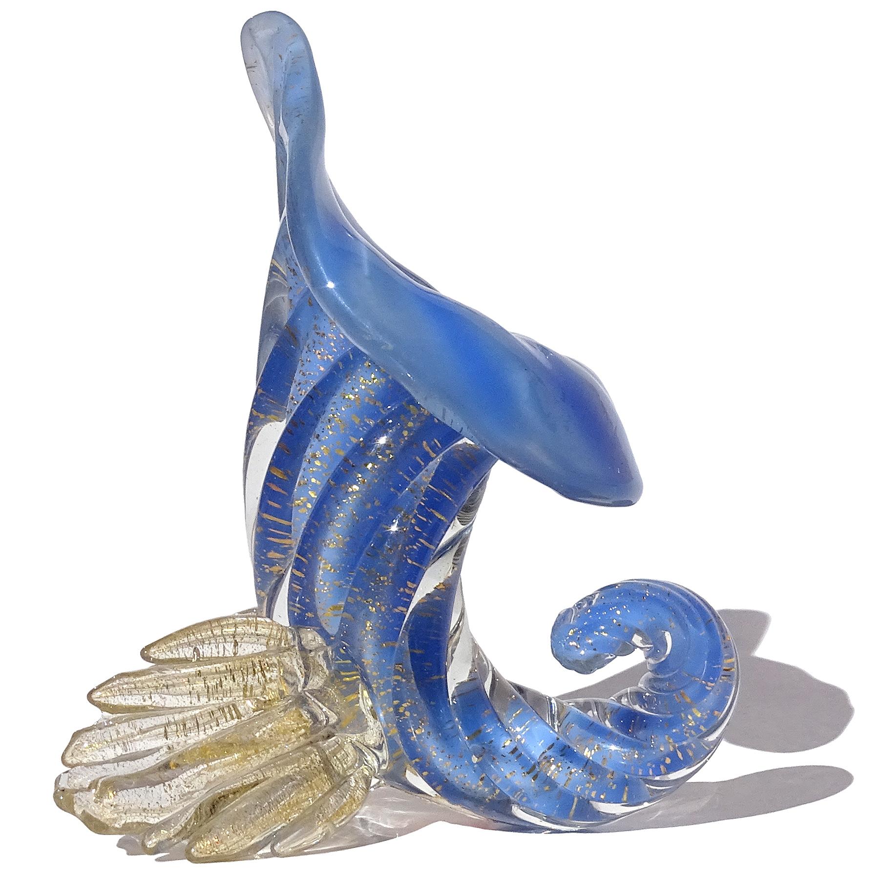 Precioso jarrón en miniatura de cristal artístico italiano de Murano, soplado a mano, de color azul opalino y motas doradas, con forma de flor de cornucopia. Documentado al diseñador Archimede Seguso, hacia la década de 1950, y publicado en su libro