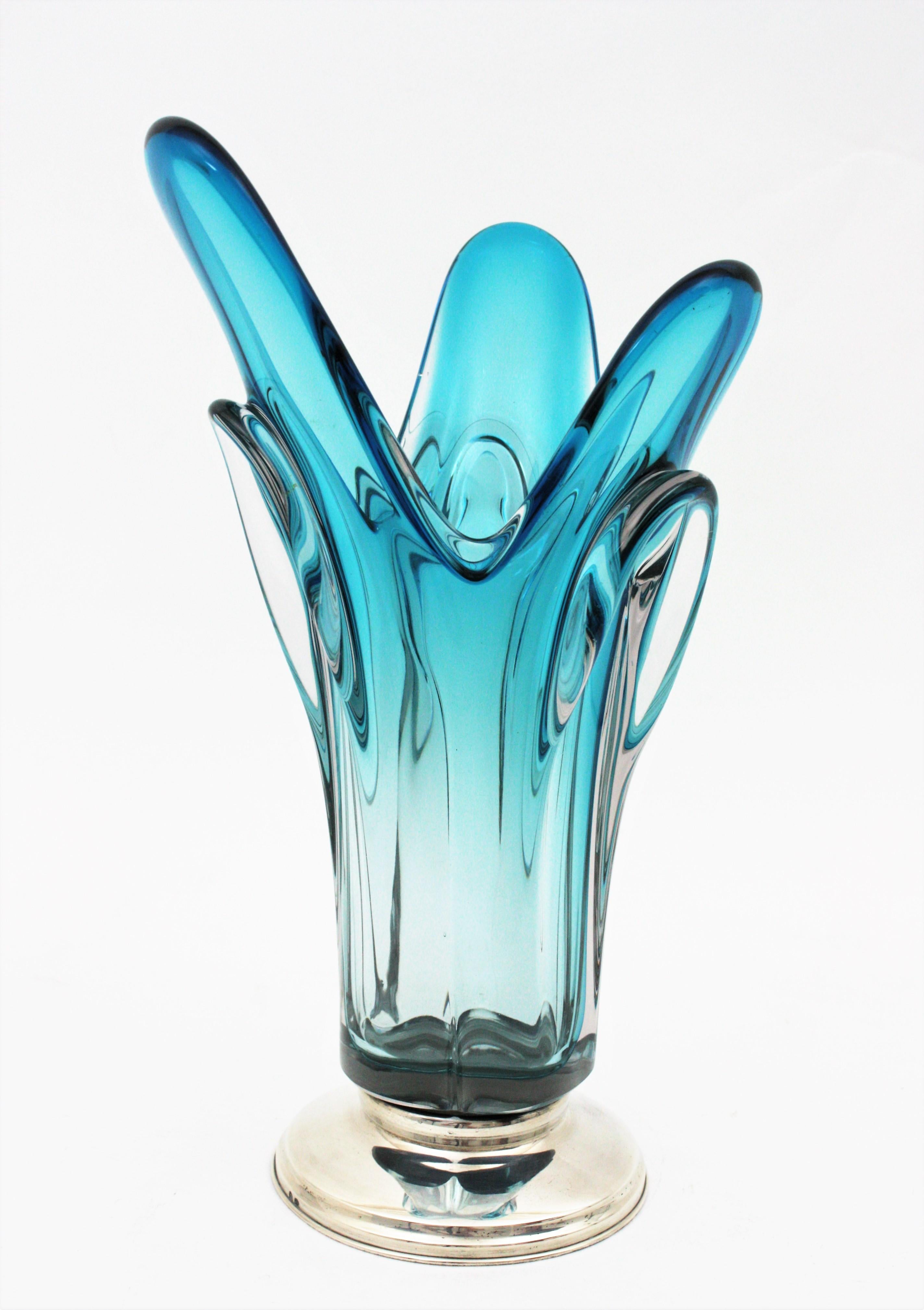 Hand blown Sommerso blue and clear Italian art glass vase on Sterling Silver base. Attributed to Seguso, Italy, 1950s.
This eye-catching and colorful pulled centerpiece vase stands up on a silver base. It has a beautiful design with pulled details