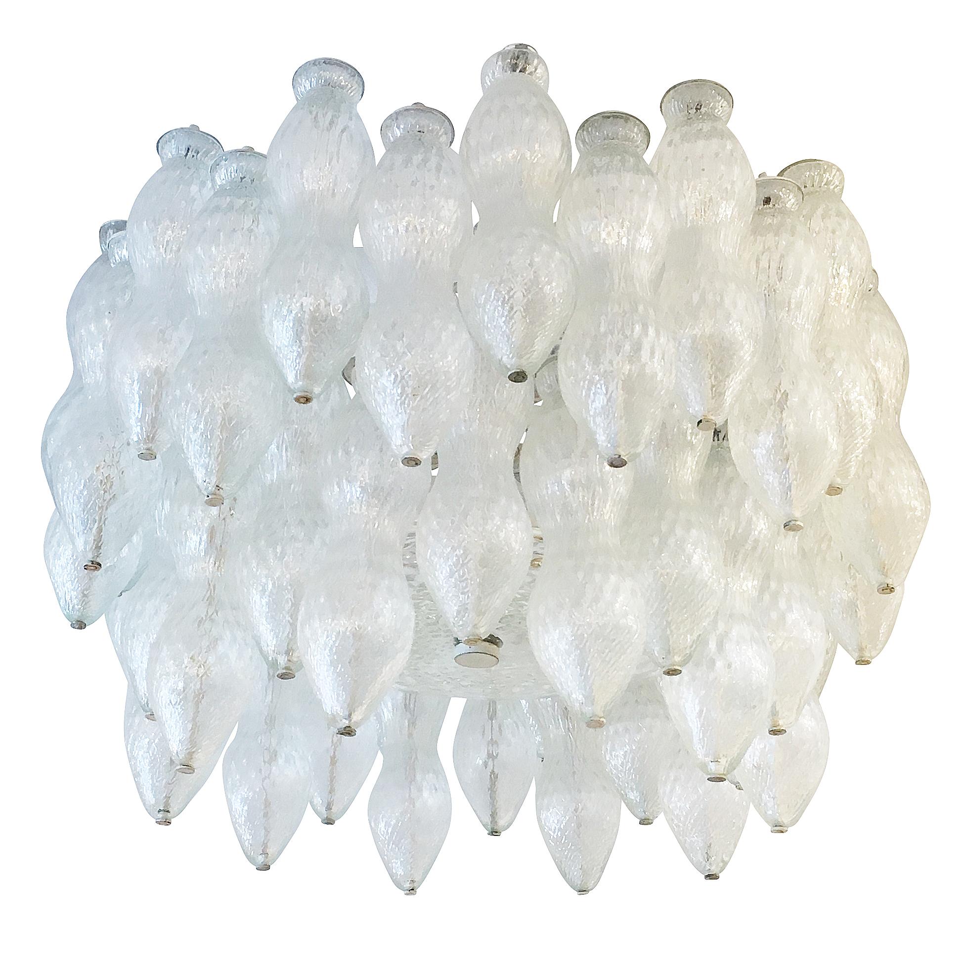 Midcentury chandelier by famous Murano glass maker Seguso. Features two rows of handblown glasses and is closed at the bottom by a textured glass disk. The glasses are clear with a slight iridescence. Holds nine candelabra sockets. Can be mounted on