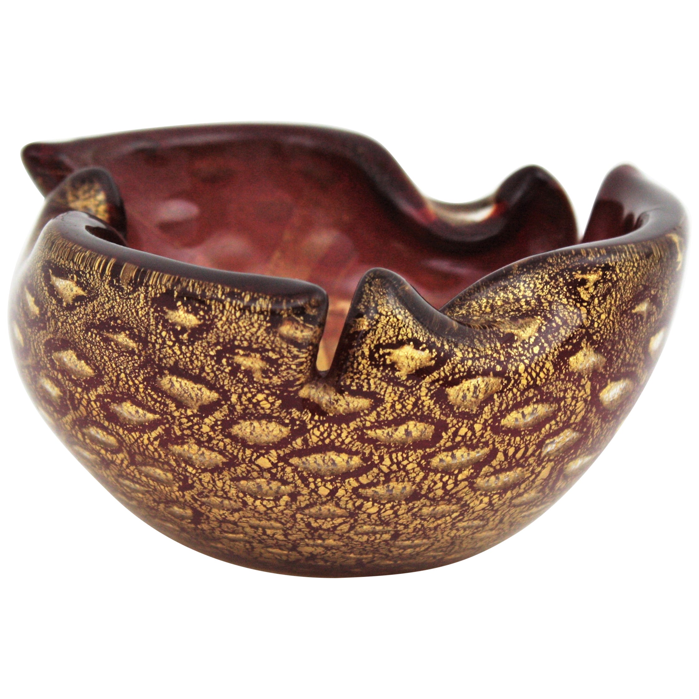 Accattivante ciotola o posacenere in vetro artistico di Murano soffiato a mano di colore rosso borgogna, con macchie d'oro e bolle controllate. Attribuito ad Archimede Seguso, Italia, anni '1950.
Questa splendida coppa di vetro ha un bordo ripiegato