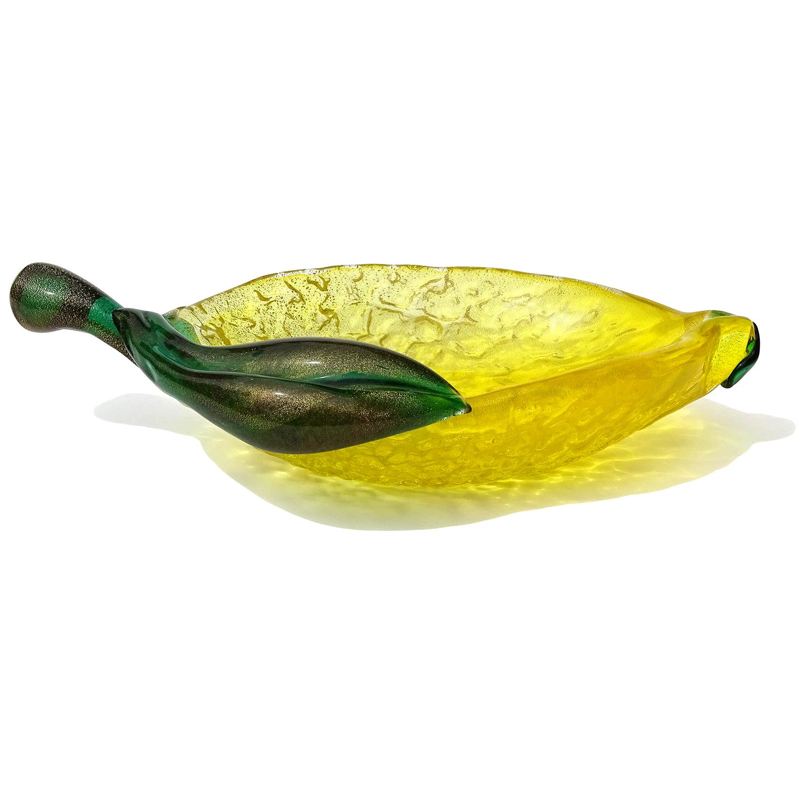 Beautiful large vintage Murano hand blown yellow, green and gold flecks Italian art glass lemon shaped fruit bowl. Documented to designer Archimede Seguso. The piece is made with a bright yellow color and textured surface. It is profusely covered in