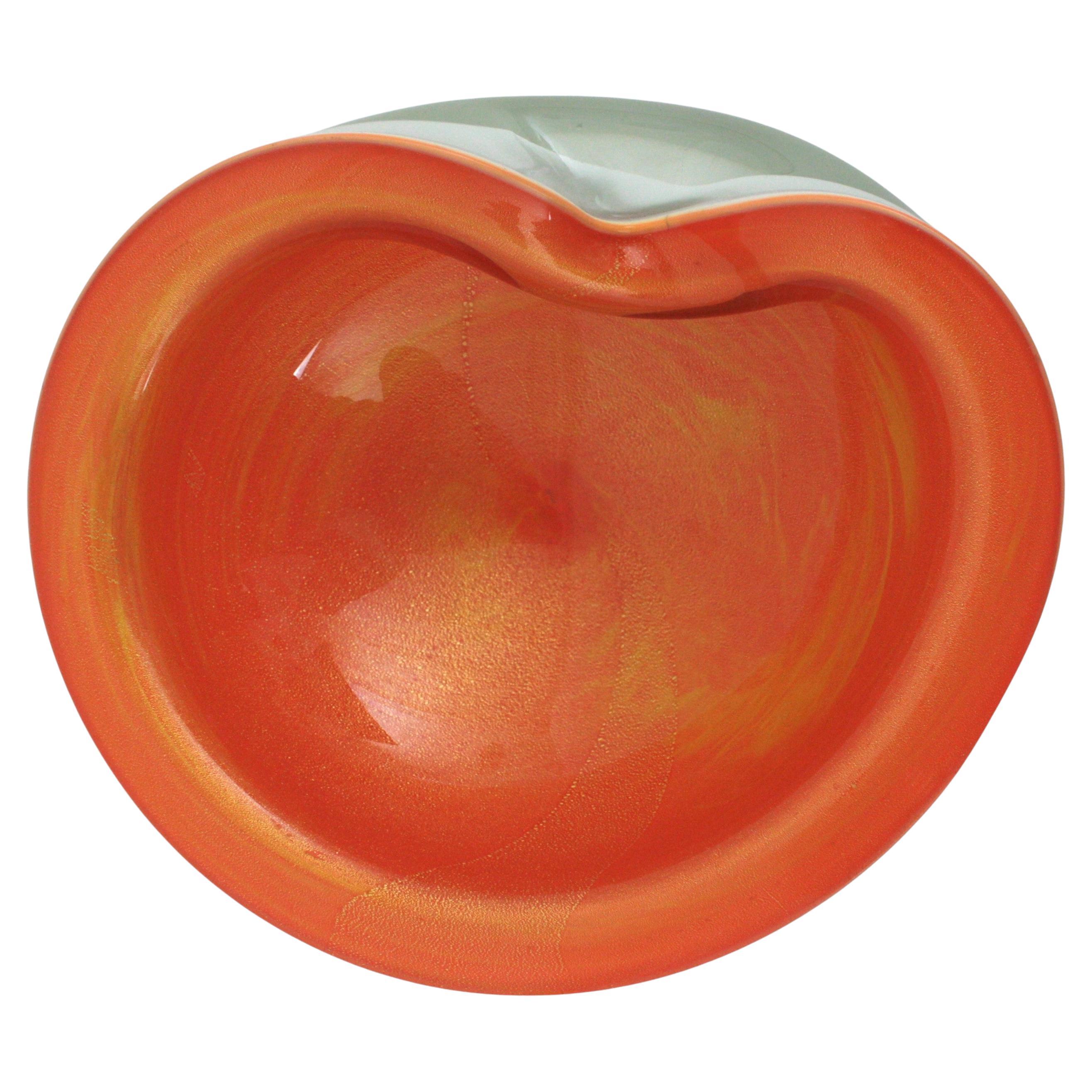 Grand bol en verre soufflé à la bouche de Murano Sommerso Orange Blanc Alabastro avec bord Foldes et poussière d'or. Attribué à Archimede Seguso. Italie, années 1950.
Verre orange de forme biomorphe sur verre blanc submergé dans du verre clair  en
