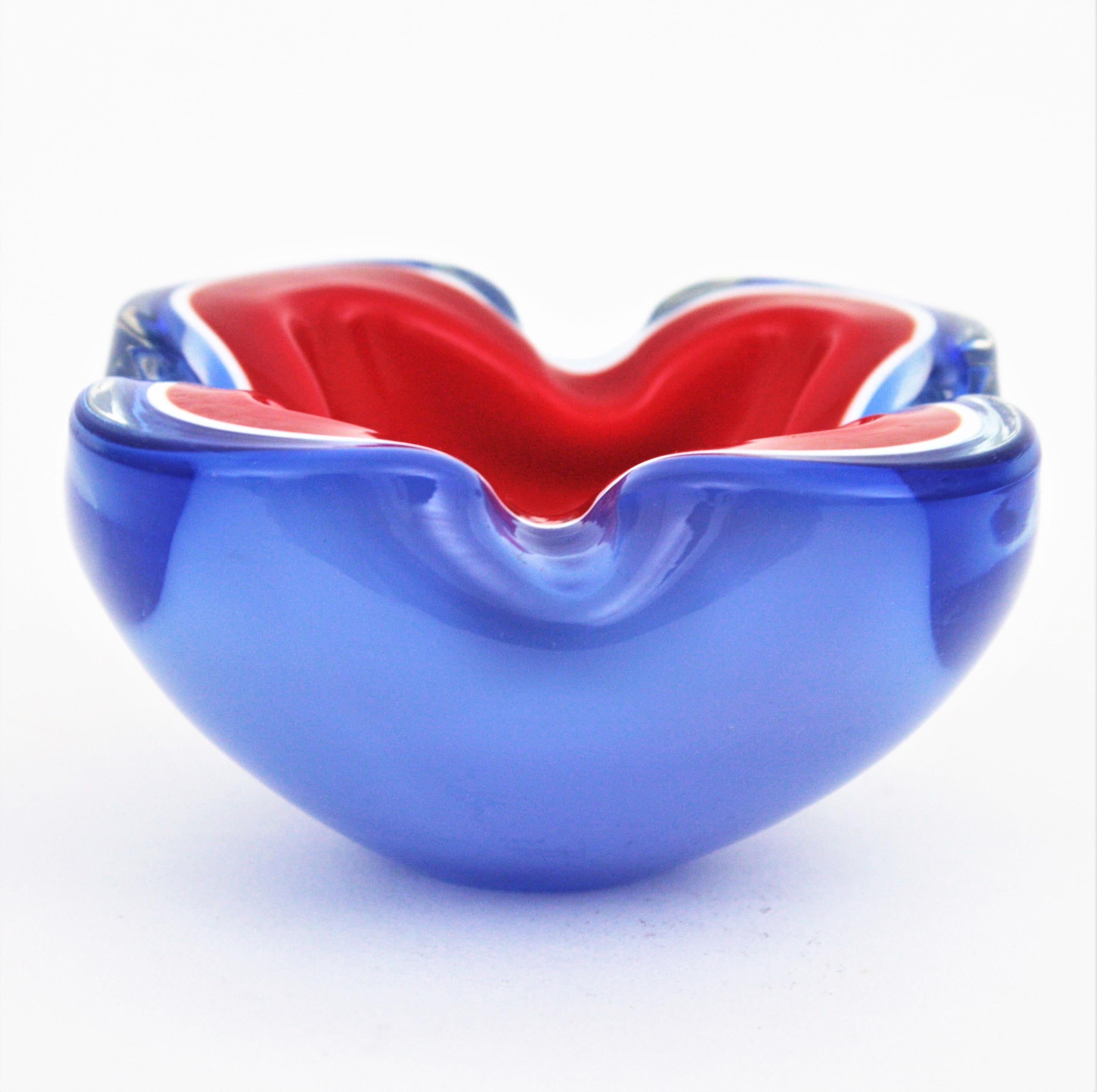 Blown glass Sommerso Murano bowl /ashtray with folded rim. Attributed to Archimede Seguso, Italy, 1950s-1960s.
Triple cased red, white and blue blue glass with the Sommerso technique. It has highly decorative shapes and it is an spectacular piece