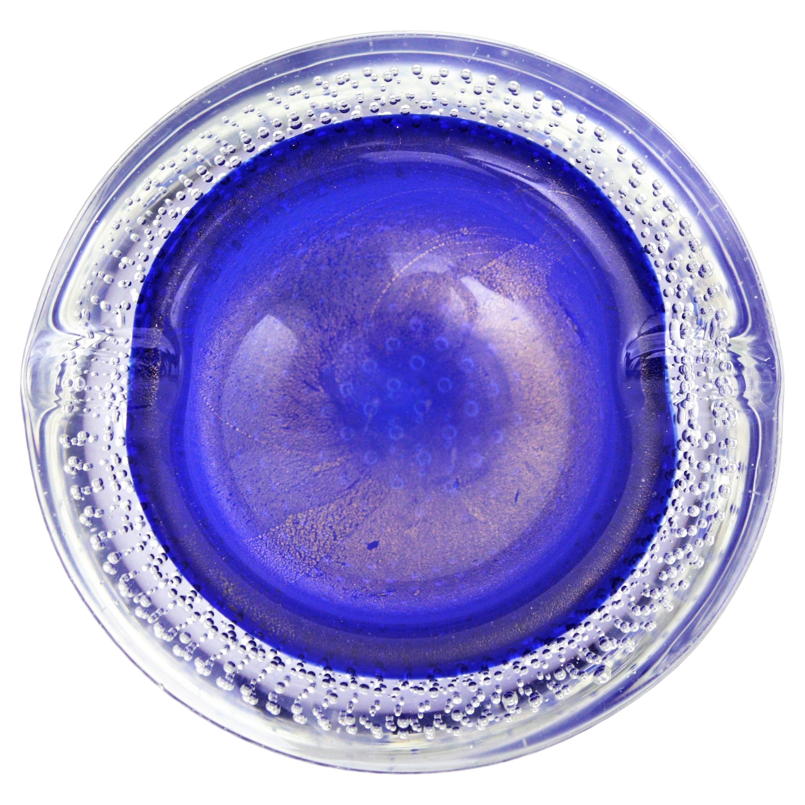 Bullicante Goldstaub Kunstglasschale oder Aschenbecher, Italien, 1950er Jahre.
Wird Flavio Poli für Seguso zugeschrieben.
Diese auffällige kobaltblaue Murano-Schale aus italienischem Sommerso-Glas ist aus blauem Glas gefertigt, das in der