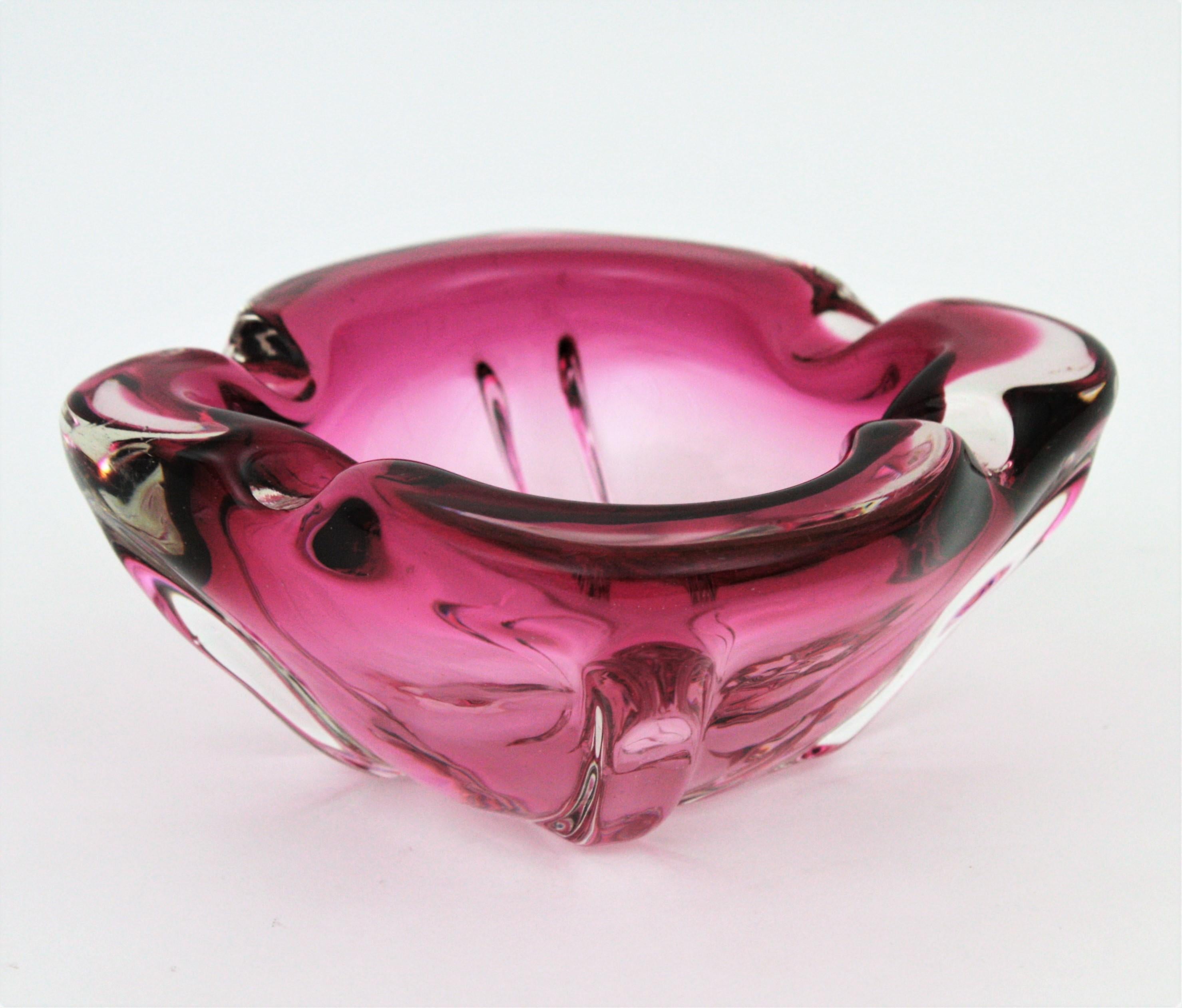 Lovely Murano glass Sommerdo decorative bowl or ashtray in pink and clear glass. Attributed to Seguso, Italy, 1960s.
This handblow art glass piece was handcrafted in shades of fuchsia to pink glass submerged into clear glass. It has a nice design
