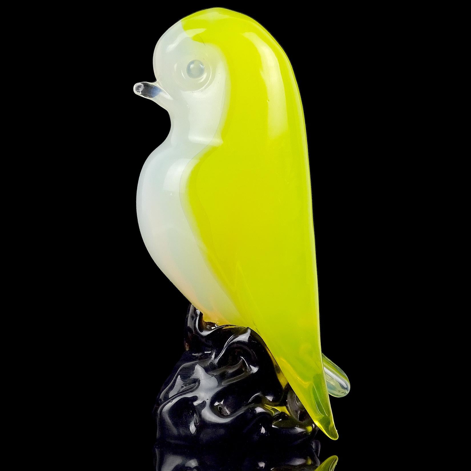 Beautiful vintage Murano hand blown, opalescent white and bright yellow Italian art glass bird figurine / sculpture. Documented to designer Archimede Seguso. This cute bird has contrasting blue eyes to his yellow feathers, and stands on a dark base.