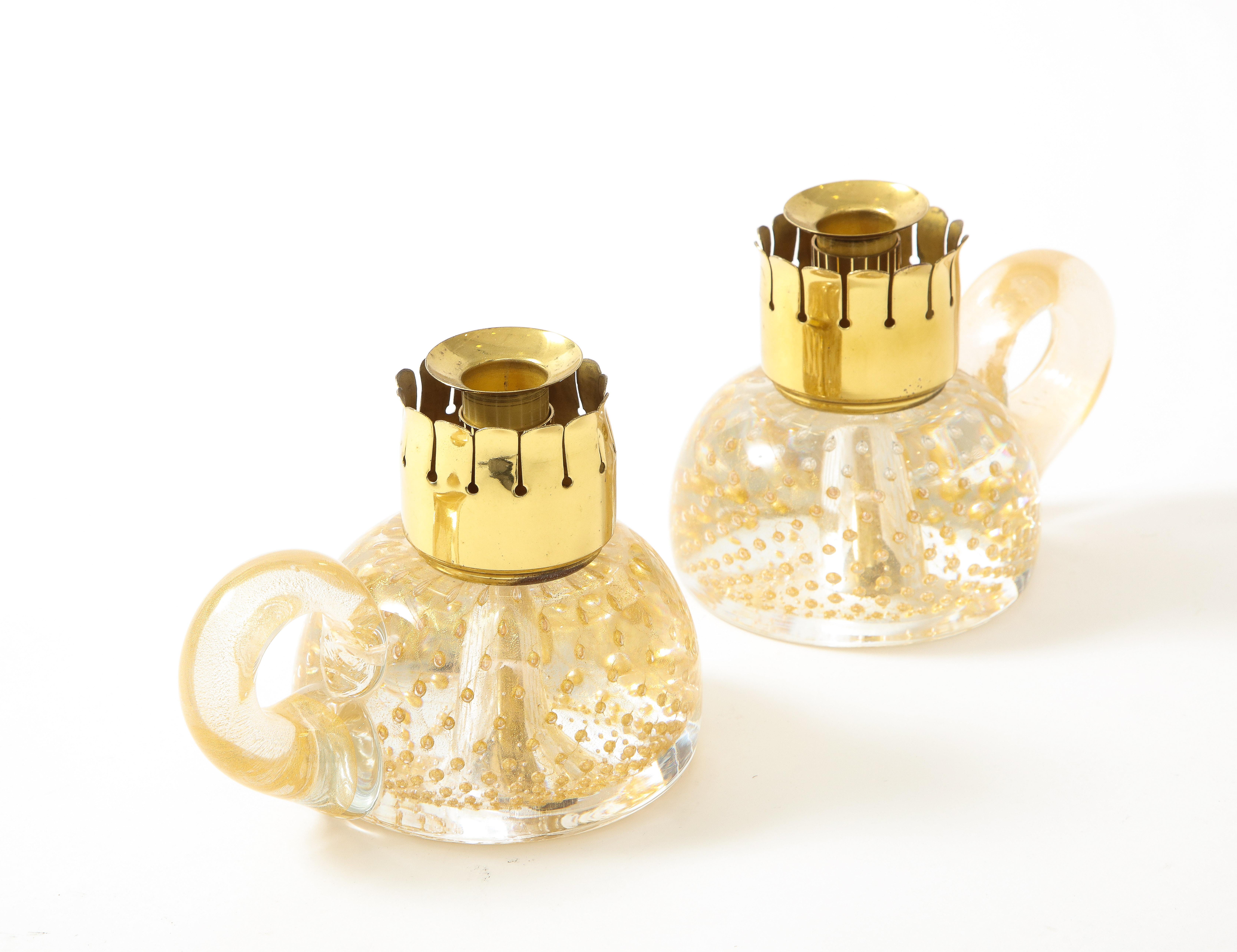 Archemide Seguso for Seguso Vetri d'Arte rare and exquisite pair of blown glass candle holders consisting of stem and handles in transparent glass with gold leaf inclusions and stylized cutout brass holder above, Italy, 1950s.