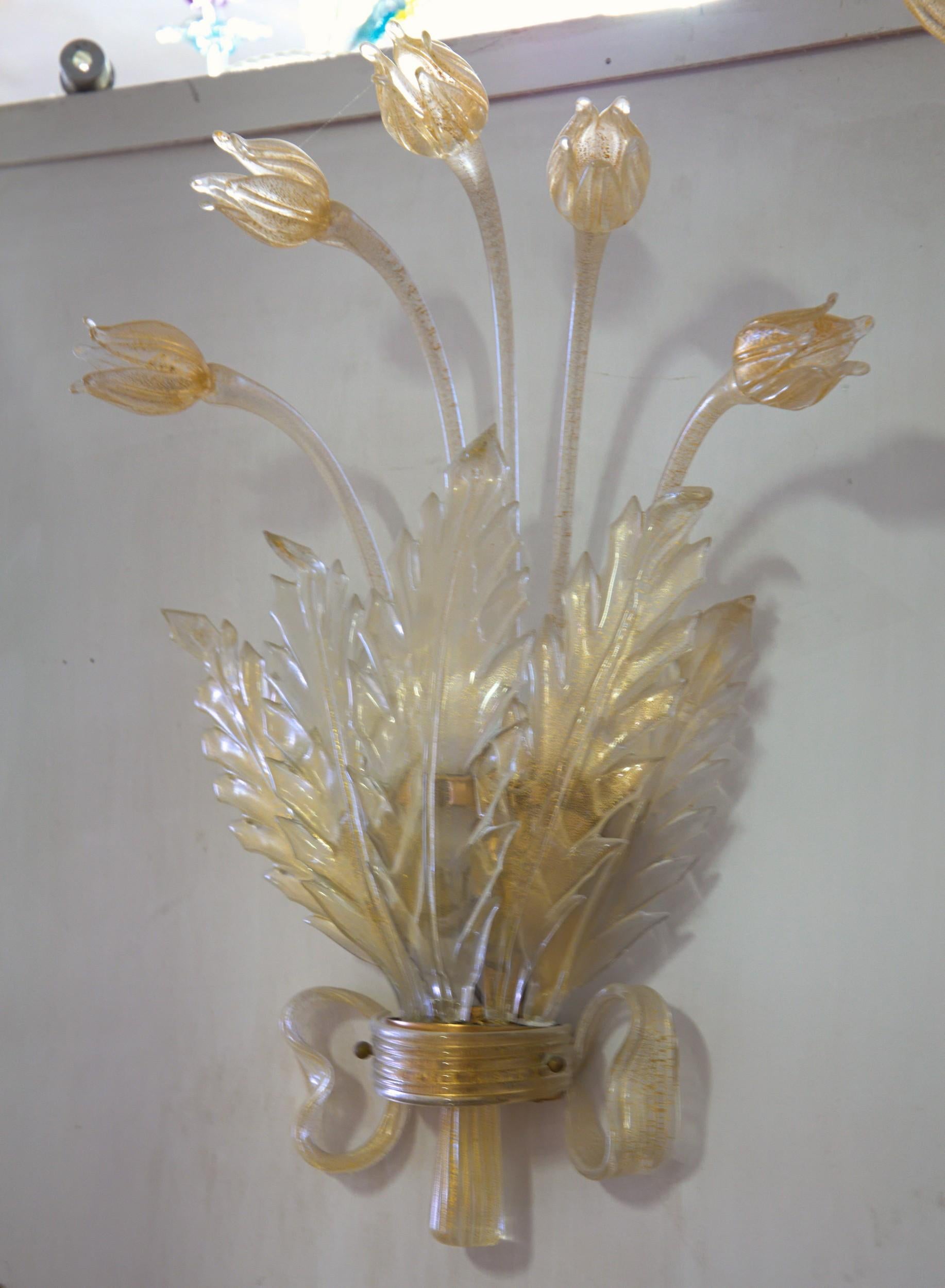 Pair of luxury detailed and elaborated sconces.
Sconce has the hardware covered by a glass ribbon and hosts 5 hand shaped leaves and 5 tulips.
The base is ornate with a bow resembling glass ribbon.
Attributed to Seguso Vetri d'Arte from the