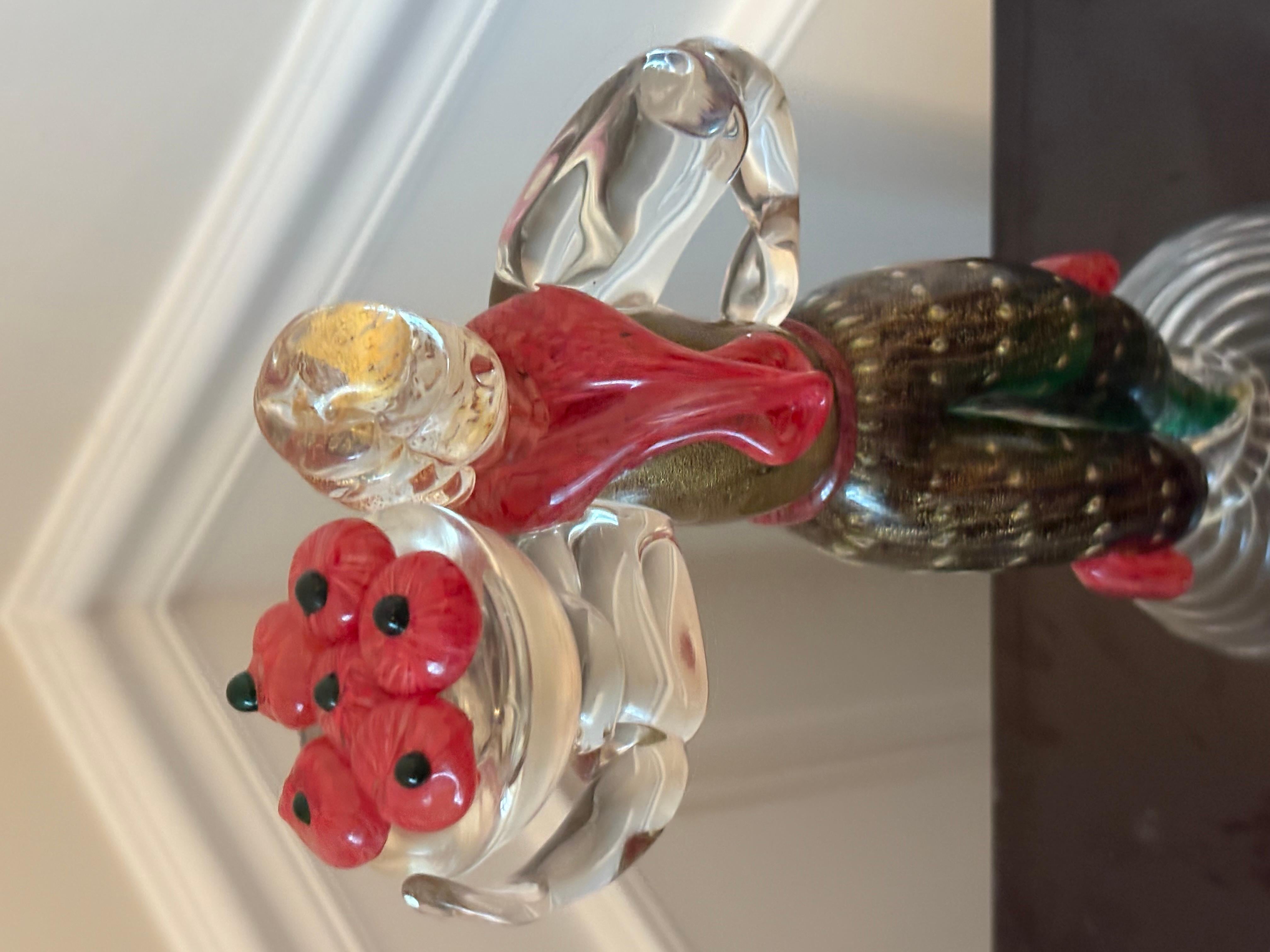 Lady carrying a bowl of tomatoes On a clear swirling base. Green dress , gold bodice, red scarf, sleeves in clear glass, hair in gold fleck.
just over 11 inches high
sculpture is unsigned