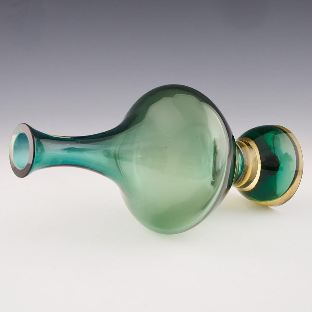 Intitulé : Vase bouteille en verre Seguso sommerso
Date : c1965
Origine : Murano, Italie
Caractéristiques du bol : Verre bleu-vert en forme de bouteille avec un pied piédestal proéminent en ambre pâle et vert. Etiquettes en papier originales sur la