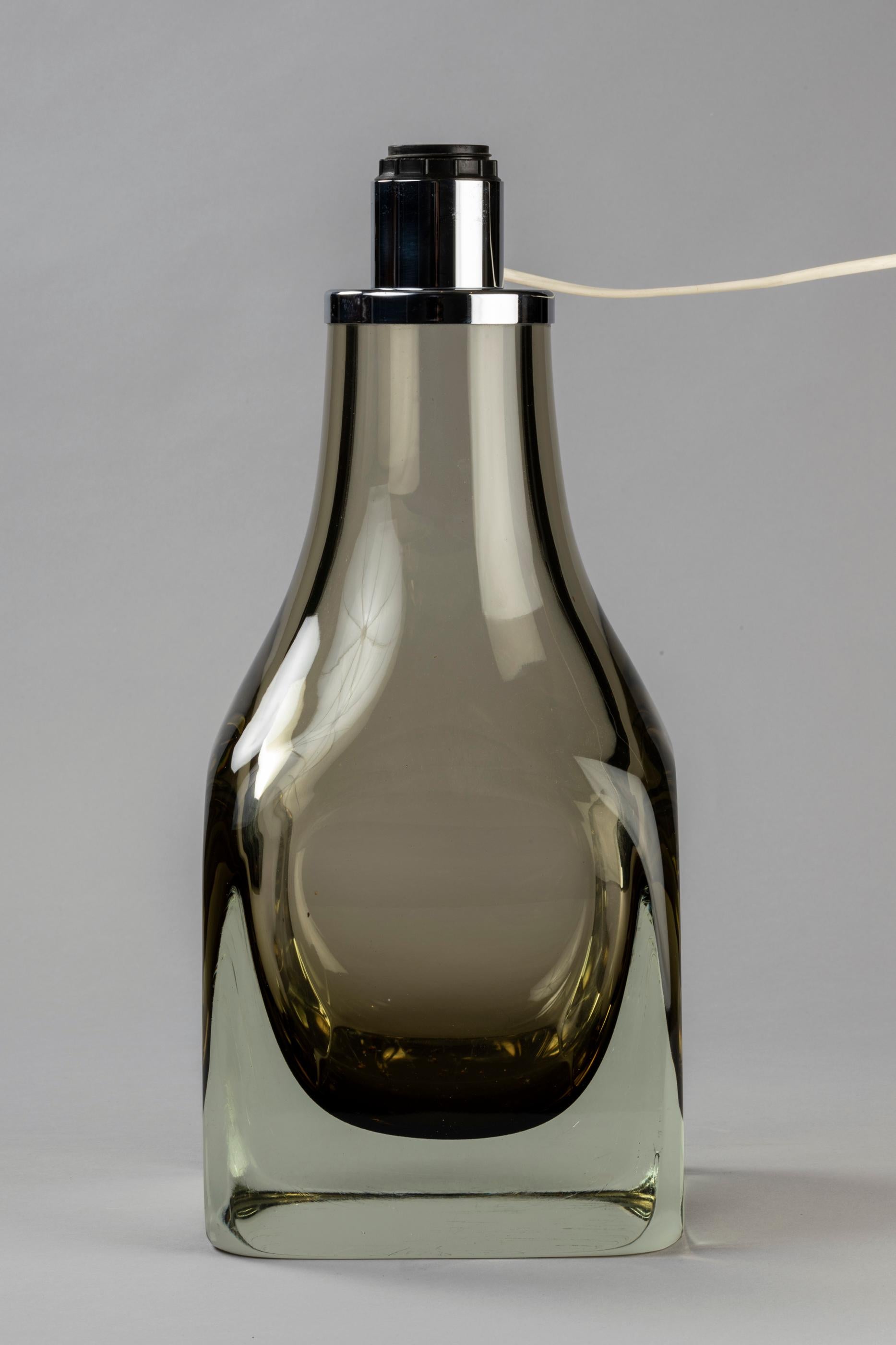 A beautiful mouth blown glass vase wish was rebuilt to table lamp in the 1960s by designer Angelo Seguso for Seguso vetri d'Arte.
A timeless style for this khaki colored lamp, full of elegance.
