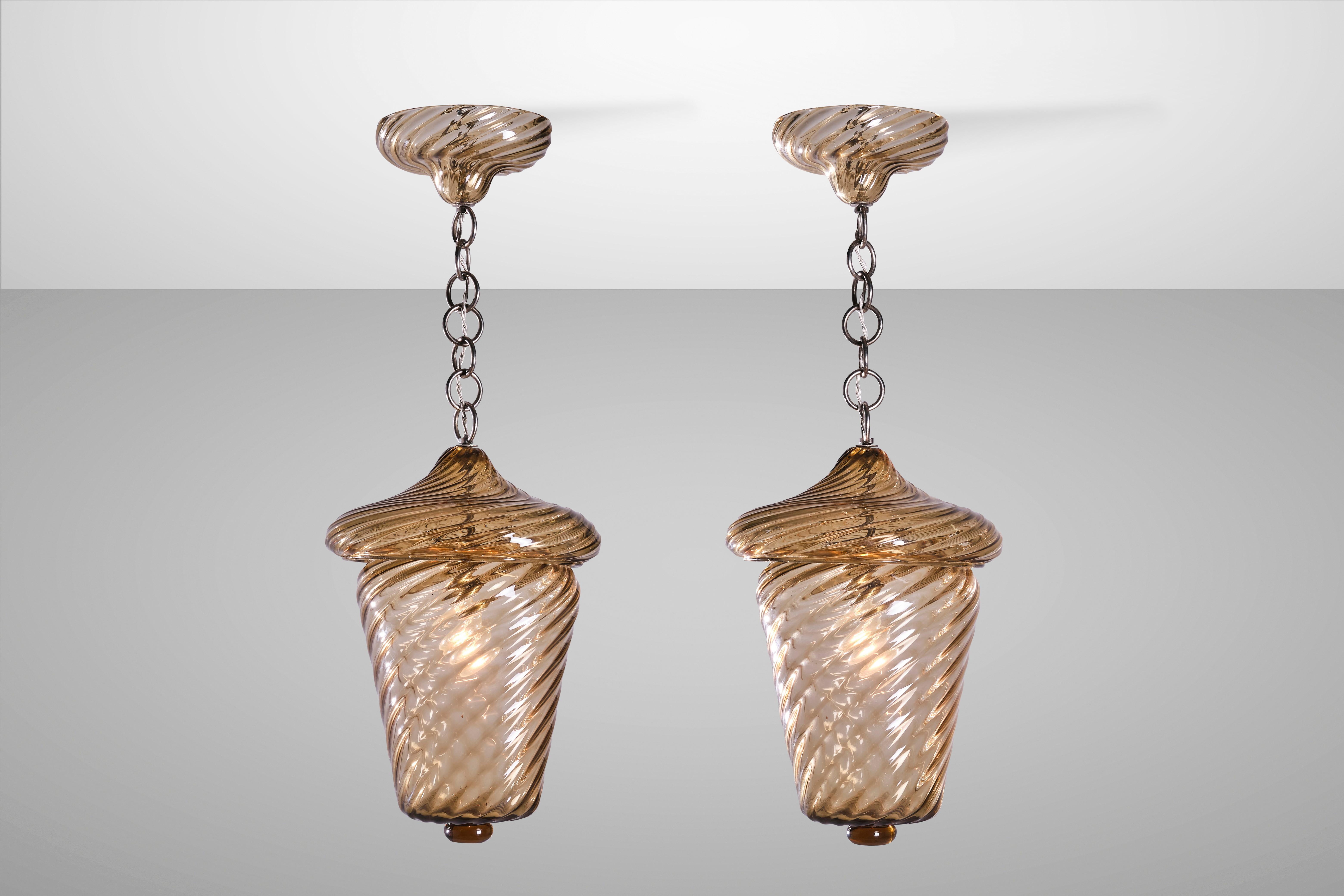 Lighting that manages to be both decorative and functional at the same time is one that becomes a classic over time. These amber-coloured lantern pendants made of twisted Rigadin (striped) blown glass are timelessly beautiful, bringing with them the