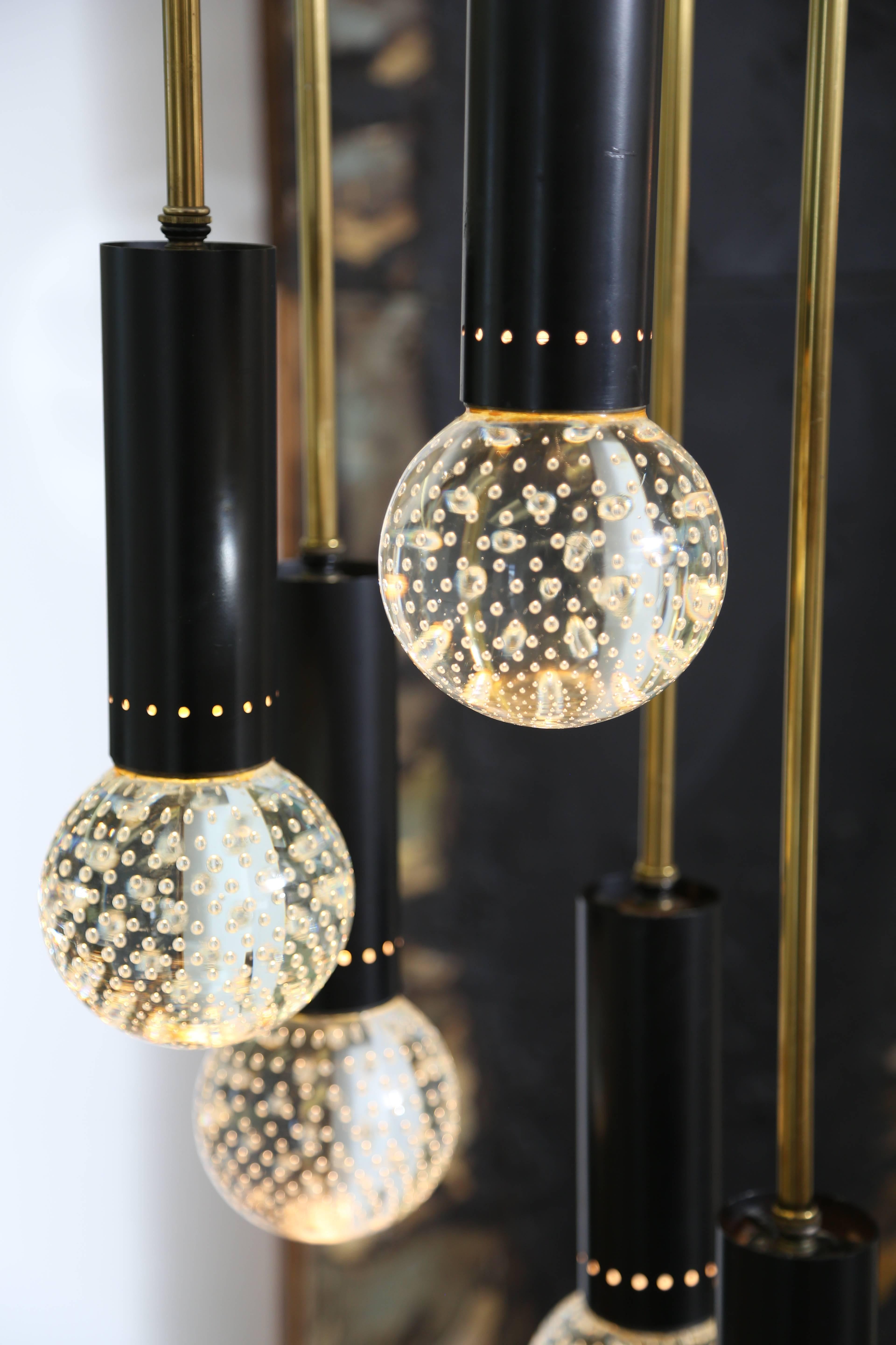 Bulicante Glass Orbs created by Seguso in Murano.
The fixture was manufactured by Lightolier.
It was not unusual for Lightolier to combine Italian and American design in the 1950s.
If you are looking for a shorter hanging fixture, these rods