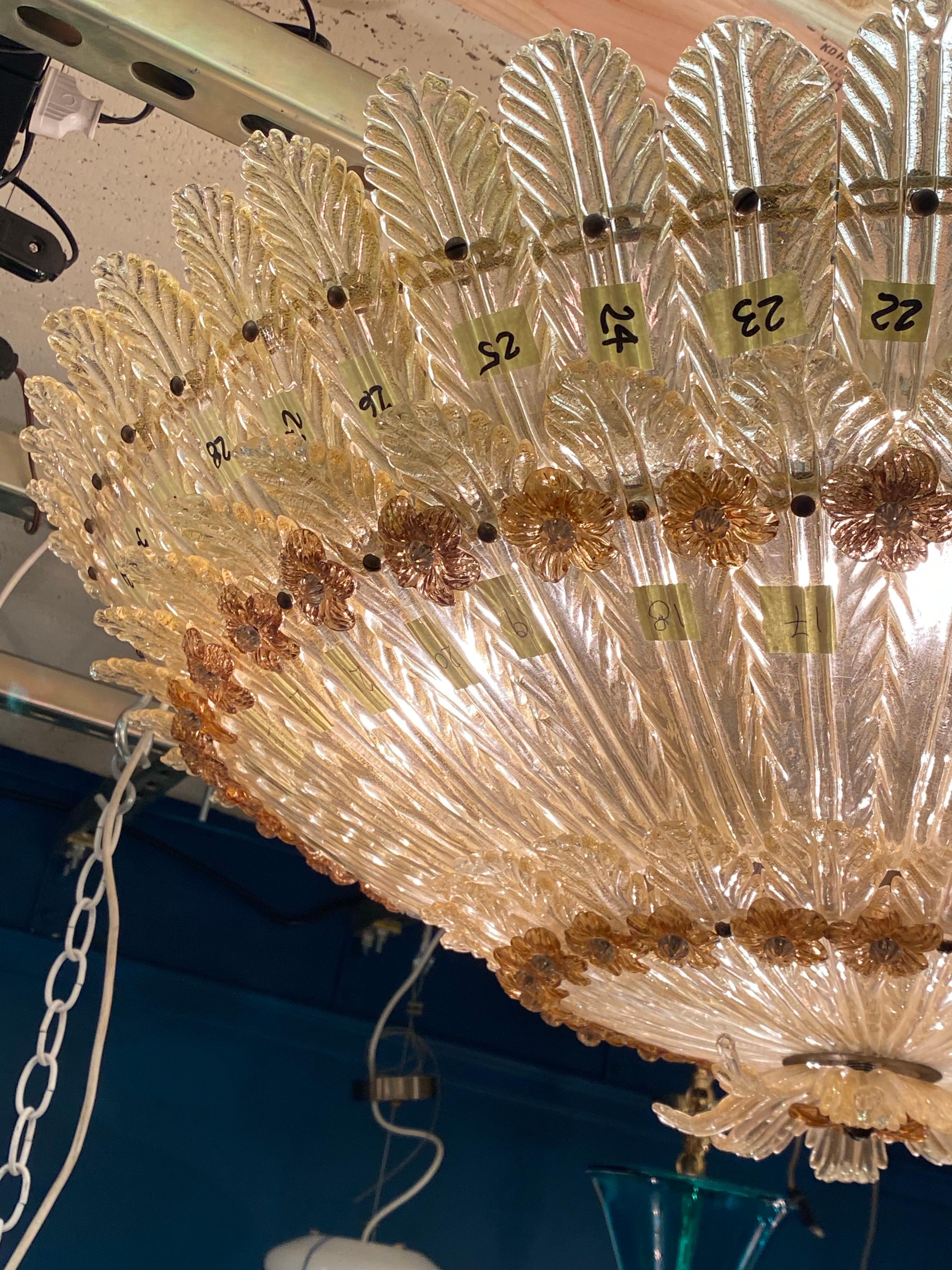 This exquisite Seguso Vetri d’Arte ceiling mount from the 1950s is a stunning example of Venetian aventurine glass craftsmanship. Measuring 33.5 inches in diameter and 13 inches high, it features hand-made glass leaves in clear and gold, along with