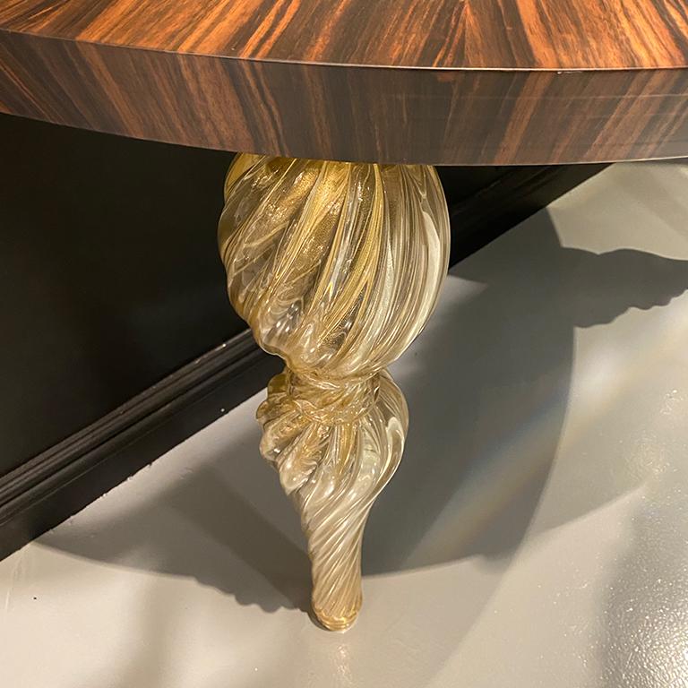 Consolle Palazzo con gambe in vetro di Murano di Seguso Vertri d'Arte. Il piano ovale della console è in noce americano. Le gambe hanno il ritorto, disegno tradizionale in oro trasparente, in vetro di Murano.
Si tratta di un campione da esposizione