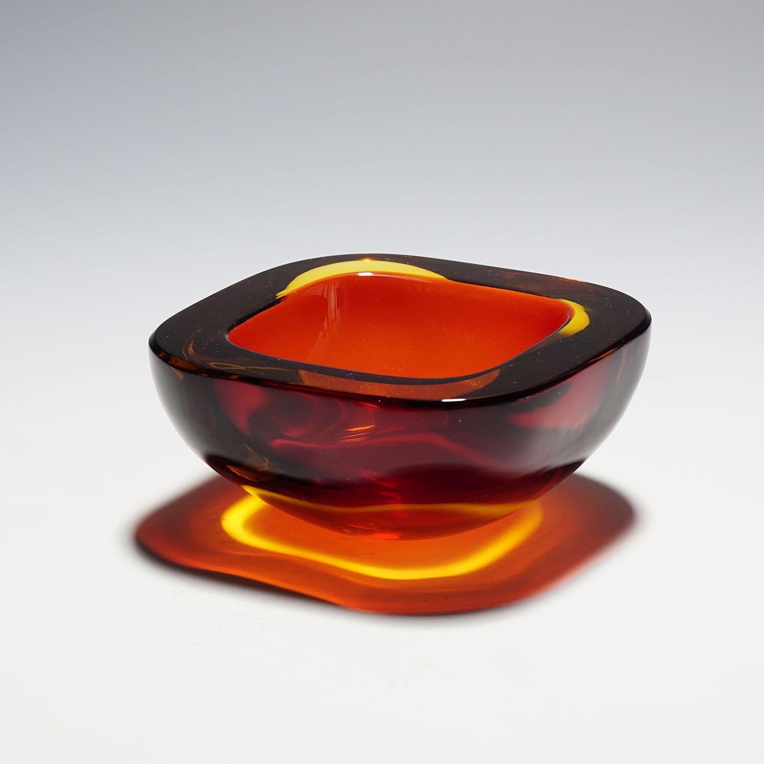 A heavy Murano sommerso glass bowl most probably manufactured by Seguso Vetri d'Arte circa 1950s. Manufactured in ruby red glass with a thick amber glass overlay. A classical design of the 60s which highlights every table or desk.

Measures: