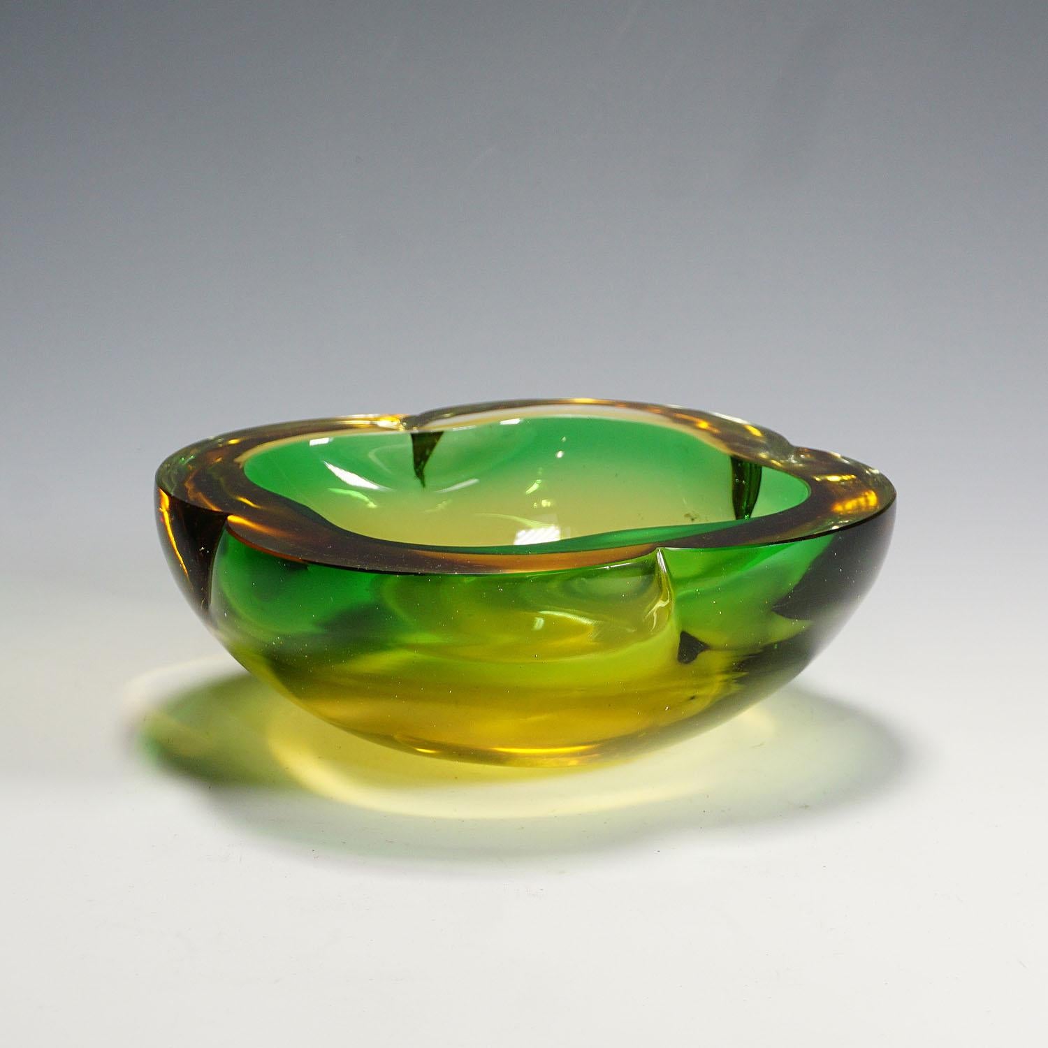 A heavy Murano sommerso glass bowl most probably manufactured by Seguso Vetri d'Arte circa 1950s. Manufactured in green glass with a thick amber glass overlay. A classical design of the 60s which highlights every table or desk.

Measures:
Width: