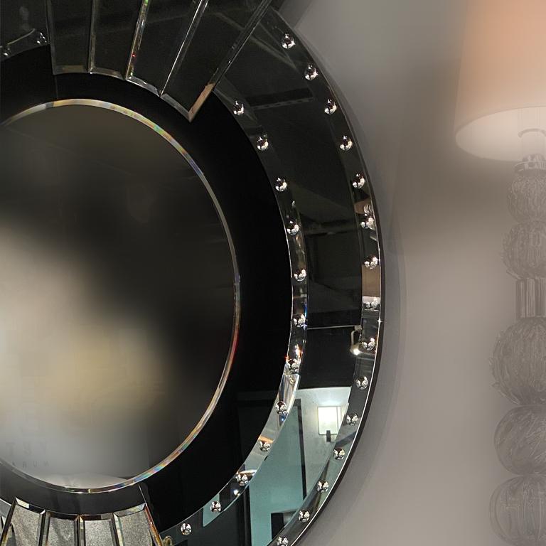 Miroir en verre de Murano par Seguso Vetri d'Arte. Un miroir rond de style contemporain mis en valeur par la nature géométrique de son cadre. La bordure irrégulière du miroir est embellie par un jeu de superposition de petites tranches en forme