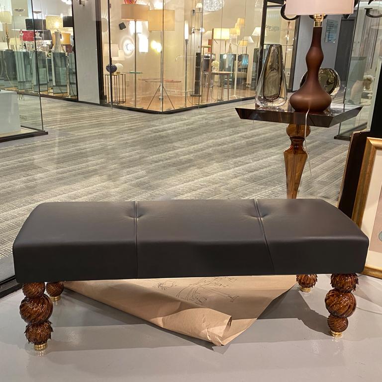 Mori collection bench with Murano glass legs by Seguso Vertri d'Arte. An elegant and versatile design that can fit into a wide range of interiors. A lather seating with taupe brown Murano glass legs anchored to a white gold metal detail. The