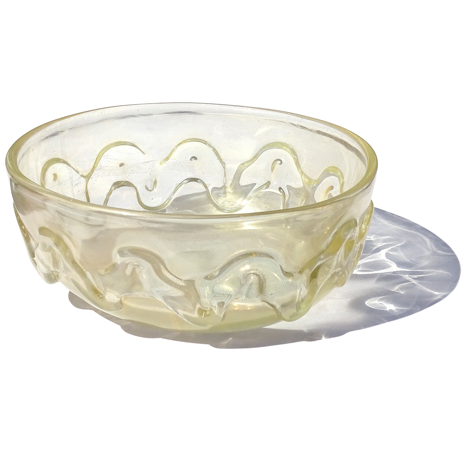 Precioso cuenco decorativo vintage de Murano soplado a mano con superficie iridiscente pesada y motas doradas de vidrio artístico italiano transparente. Atribuido al diseñador Flavio Poli para la empresa Seguso Vetri d'Arte, hacia 1930. Diseño