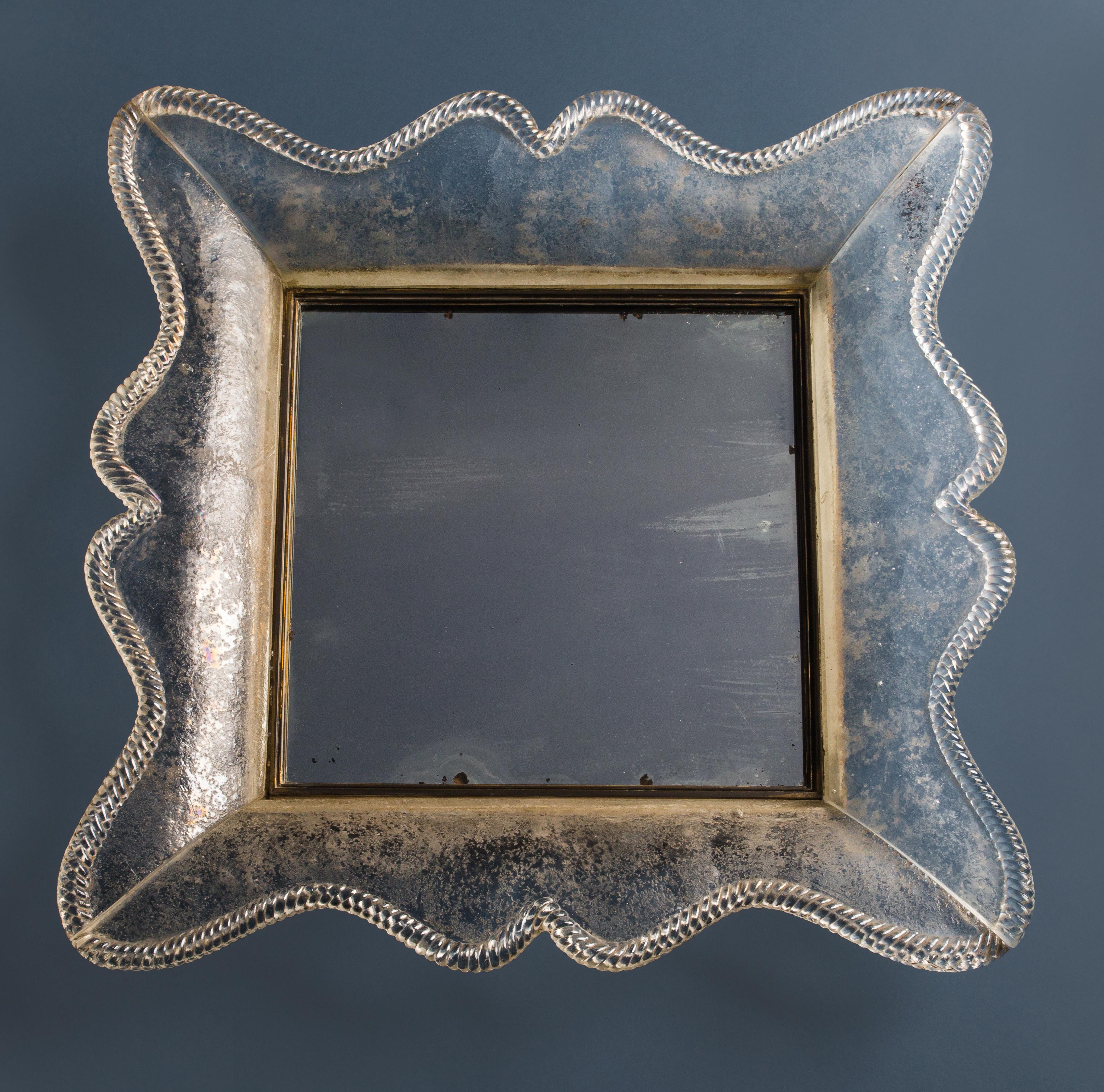 Seguso Vetri d'Arte thick smoked glass frame (appears to be tinted blue, but actually smoked clear glass with dark grey streaks) with twisted rope border, original mirrored glass mounted with brass, Italy, circa 1940. This classic and elegant mirror