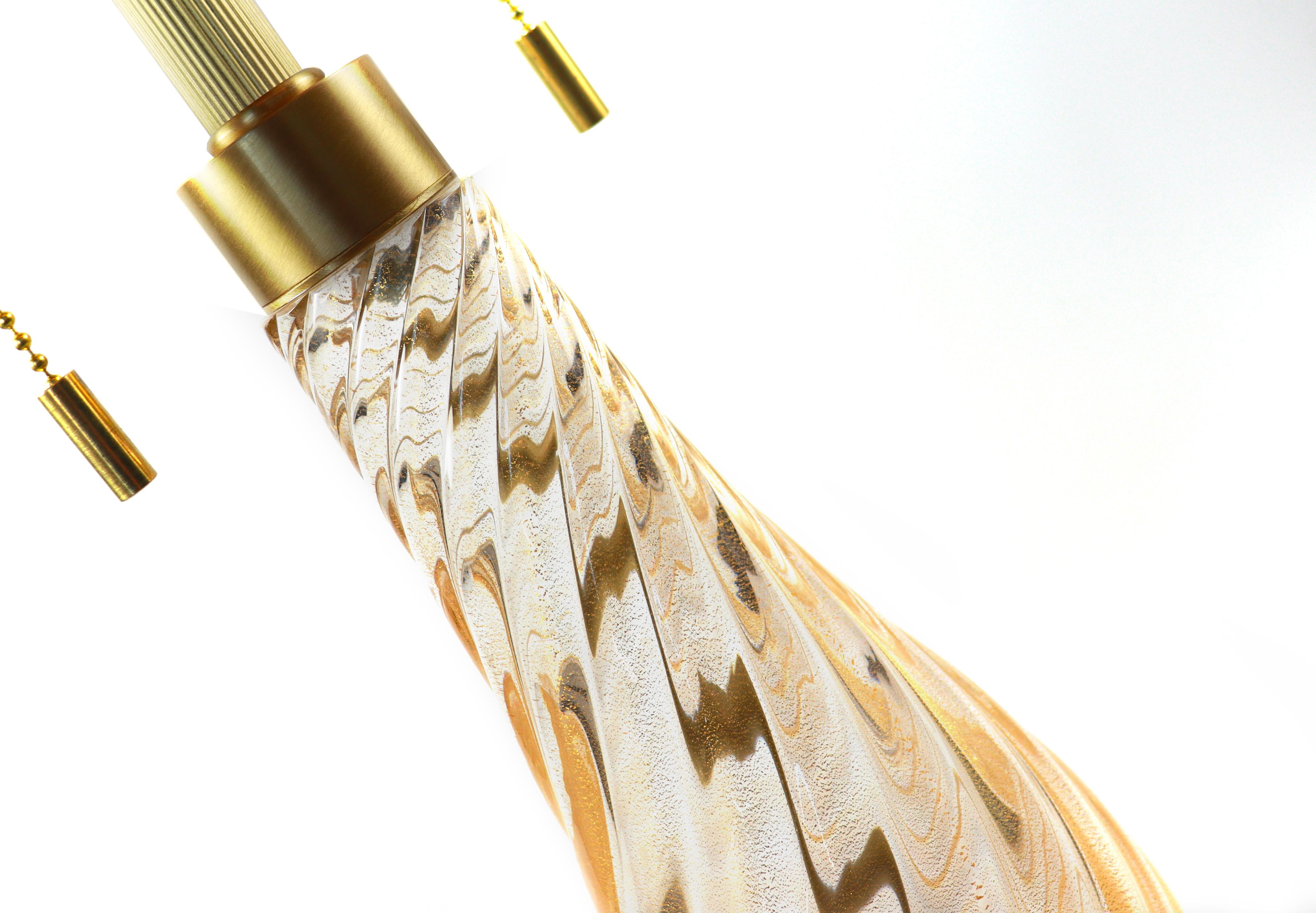 Murano glass table lamp by Seguso Vetri d’Arte. Handmade from mouth-blown clear gold glass, with a drop-shaped stem and a ribbed base. The stem is decorated with a twisted ribbed design. Available with your choice of a black or white lampshade.
