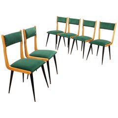 Six dining chairs from the 1950s and 1960s, made of wood with green fabric seats