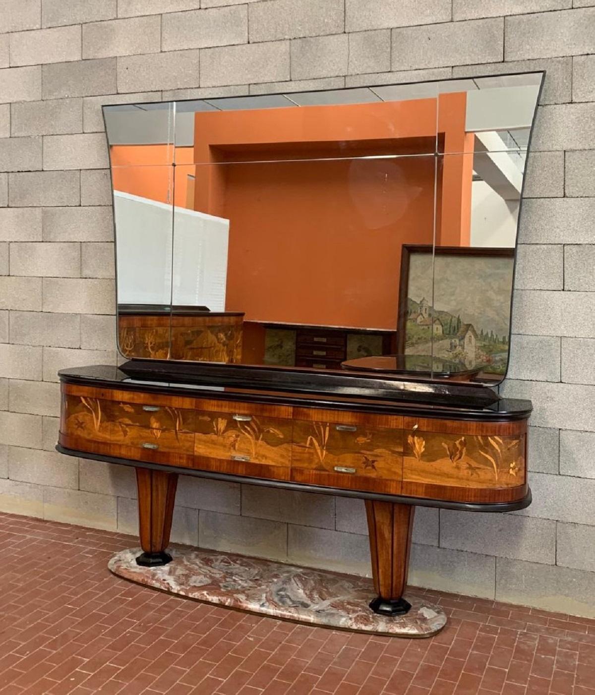 Cet important et extrêmement rare buffet avec miroir a été réalisé par Vittorio Dassi dans les années 1940/50.
La pièce repose sur une base en marbre rouge français, à partir de laquelle des pieds en forme de vase à facettes s'élèvent pour soutenir