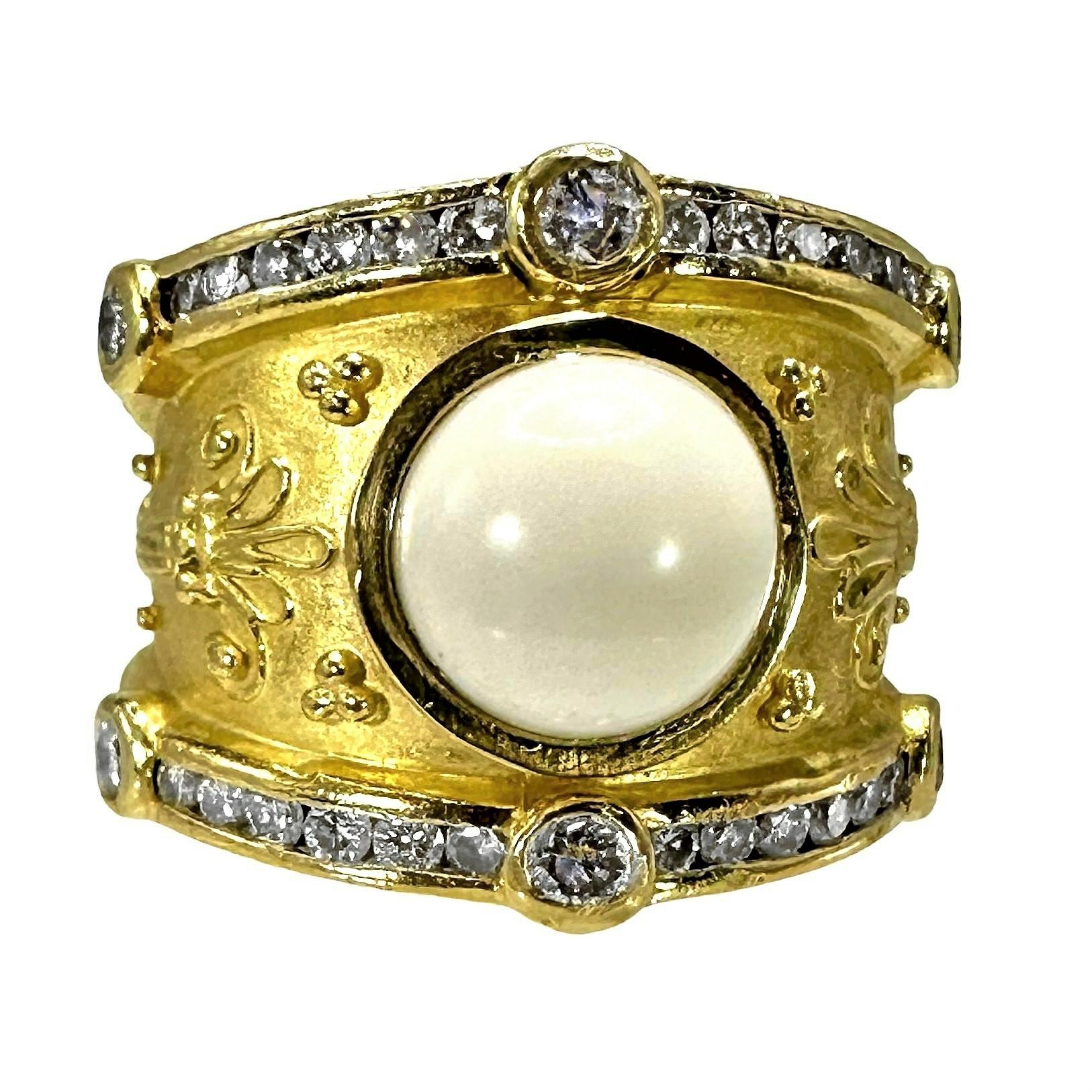 This handsome Seiden Gang Classic Revival ring is fashioned from 18K yellow gold, with an 8mm diameter white onyx cabochon at it's center. Both edges of the ring are set with a single line of round brilliant cut diamonds that extend to the ends of