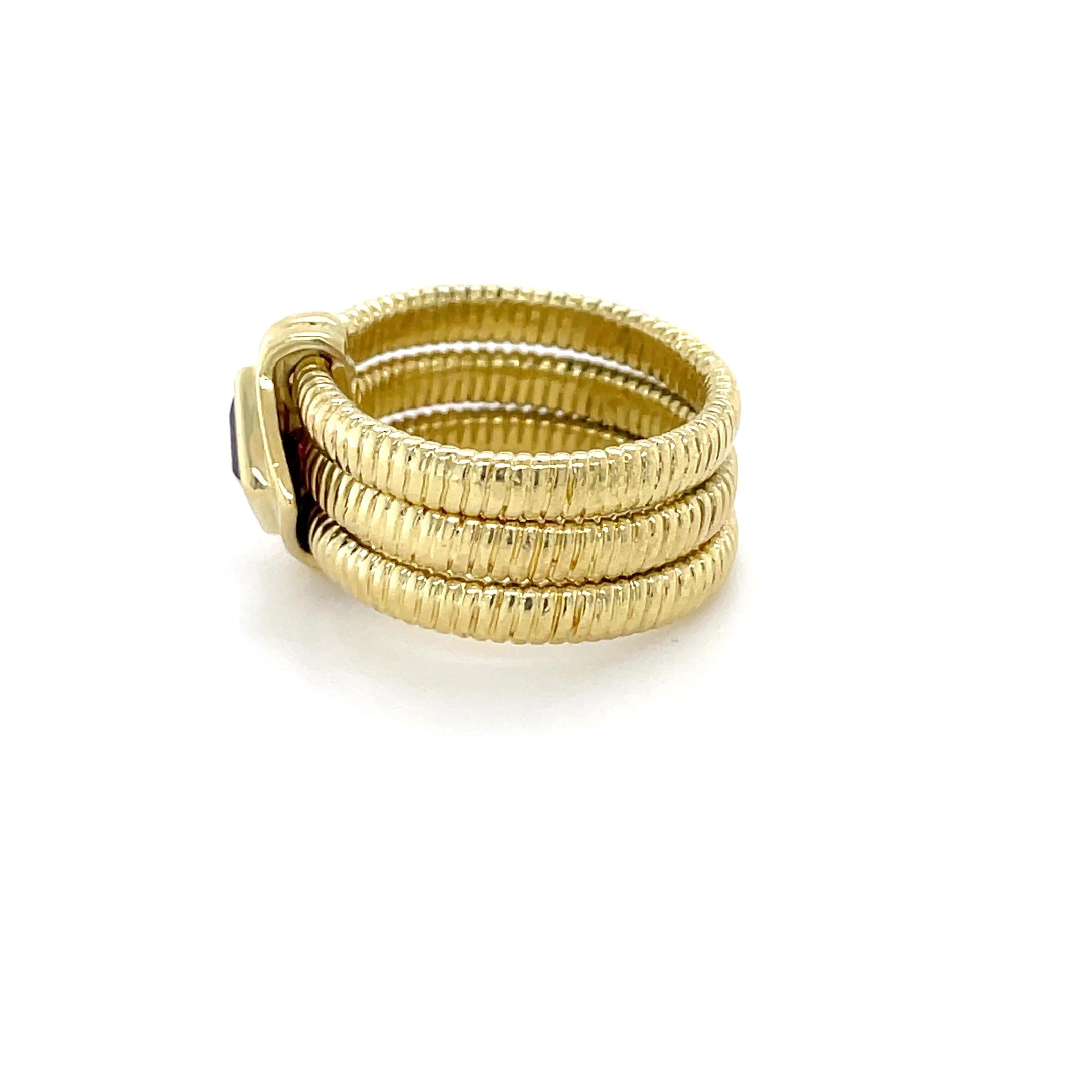 This fun ring by designer SeidenGang consists of three articulated coiled bands held together by a central station containing a square step cut garnet measuring approximately 5.00 x 5.00 mm.

Ring size: 5 3/4
Stamp: SG 18K.
Metal: 18K yellow