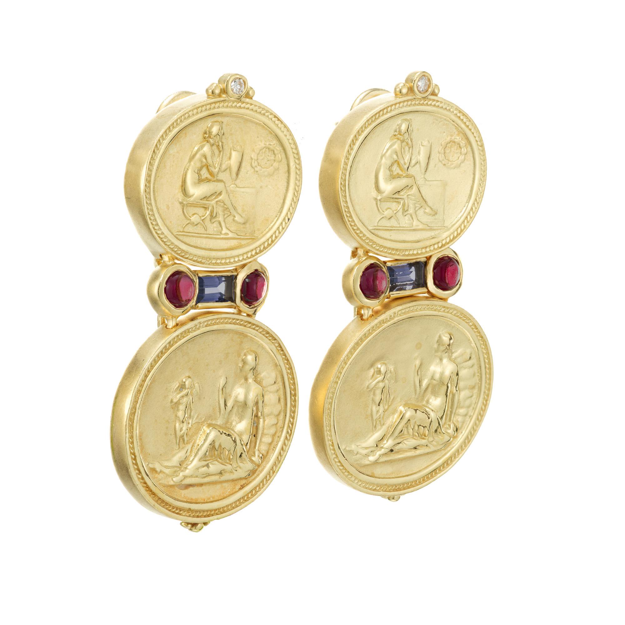 Detailed textured Seidengang dangle earrings. 18k yellow gold portrait oval discs accented with 4 round pinkish red cabochon garnets, 2 round cut diamonds and 2 purplish blue baguette Iolites. 

4 round pinkish red cabochon garnets, approx. .40cts
2