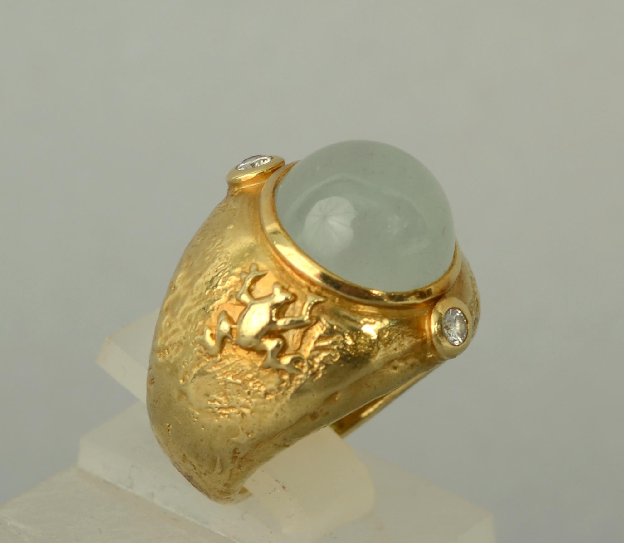 Whimsical and unusual 18 karat gold ring by Seidengang. The ring has an unexpected gold frog on one side and a turtle on the other. The central cabochon aquamarine has a diamond on either side. The gold has a nice molten texture. The ring is size 5