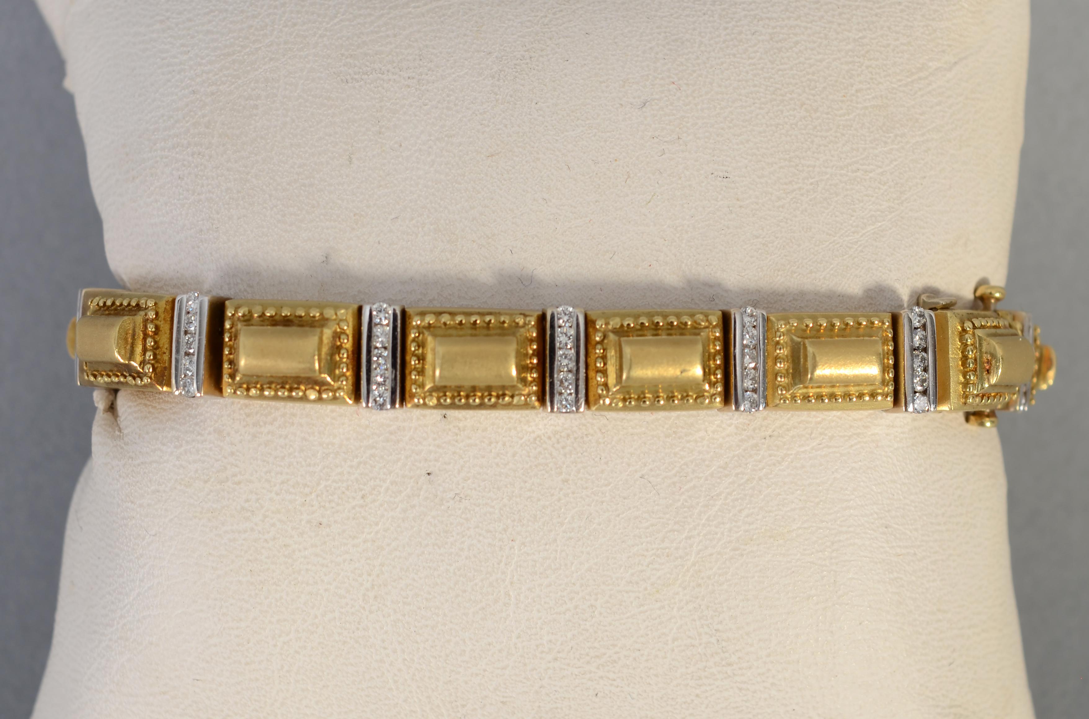 This gold bracelet by Seidengang is tailored yet has just the right touch of bling. Raised rectangular gold panels are framed with tiny gold dots. Between the rectangles are white gold links with five diamonds in each. The bracelet is 1/4 inch wide