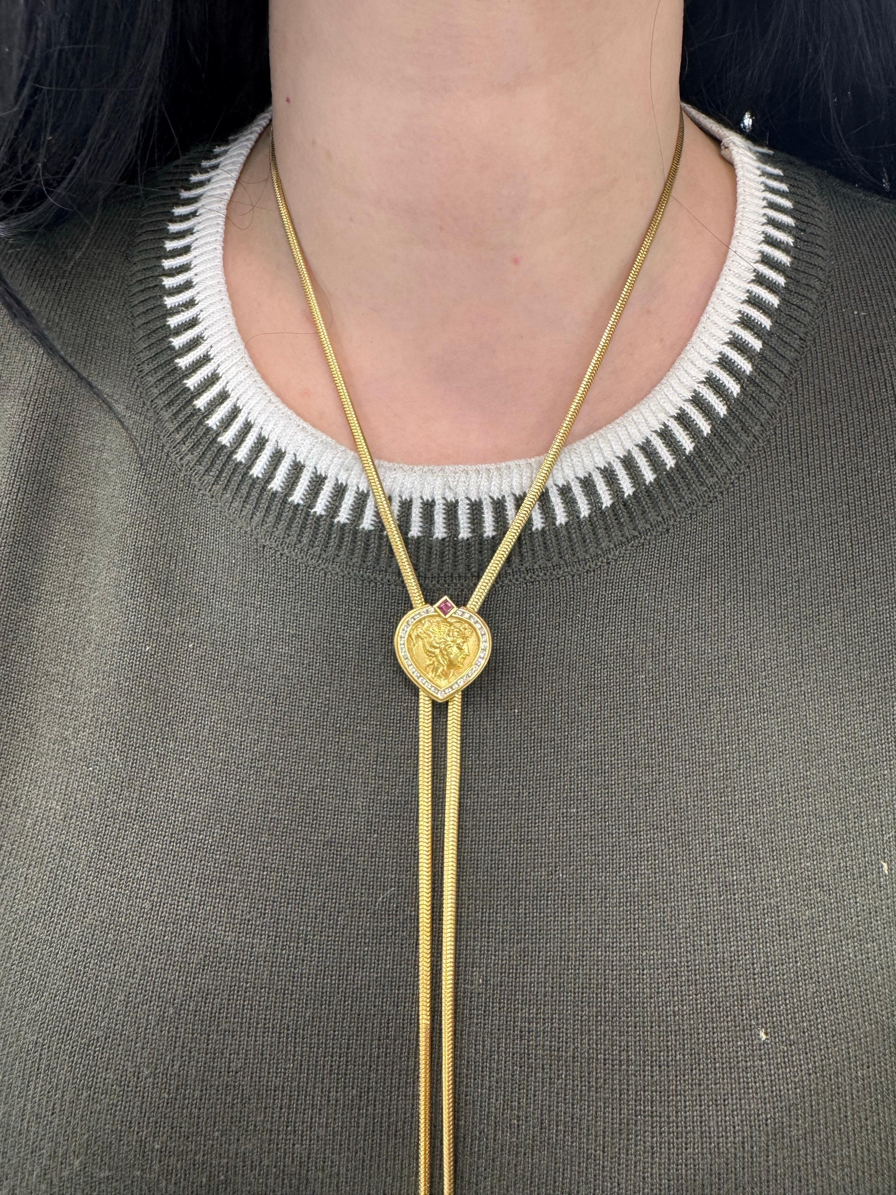 Firmato SeidenGang, questo lungo lariat presenta una donna greca circondata da 30 brillanti rotondi del peso di circa 0,40 carati in oro giallo 18 carati. Due ornamenti a forma di cuore all'estremità della collana. 
56,4 grammi
38