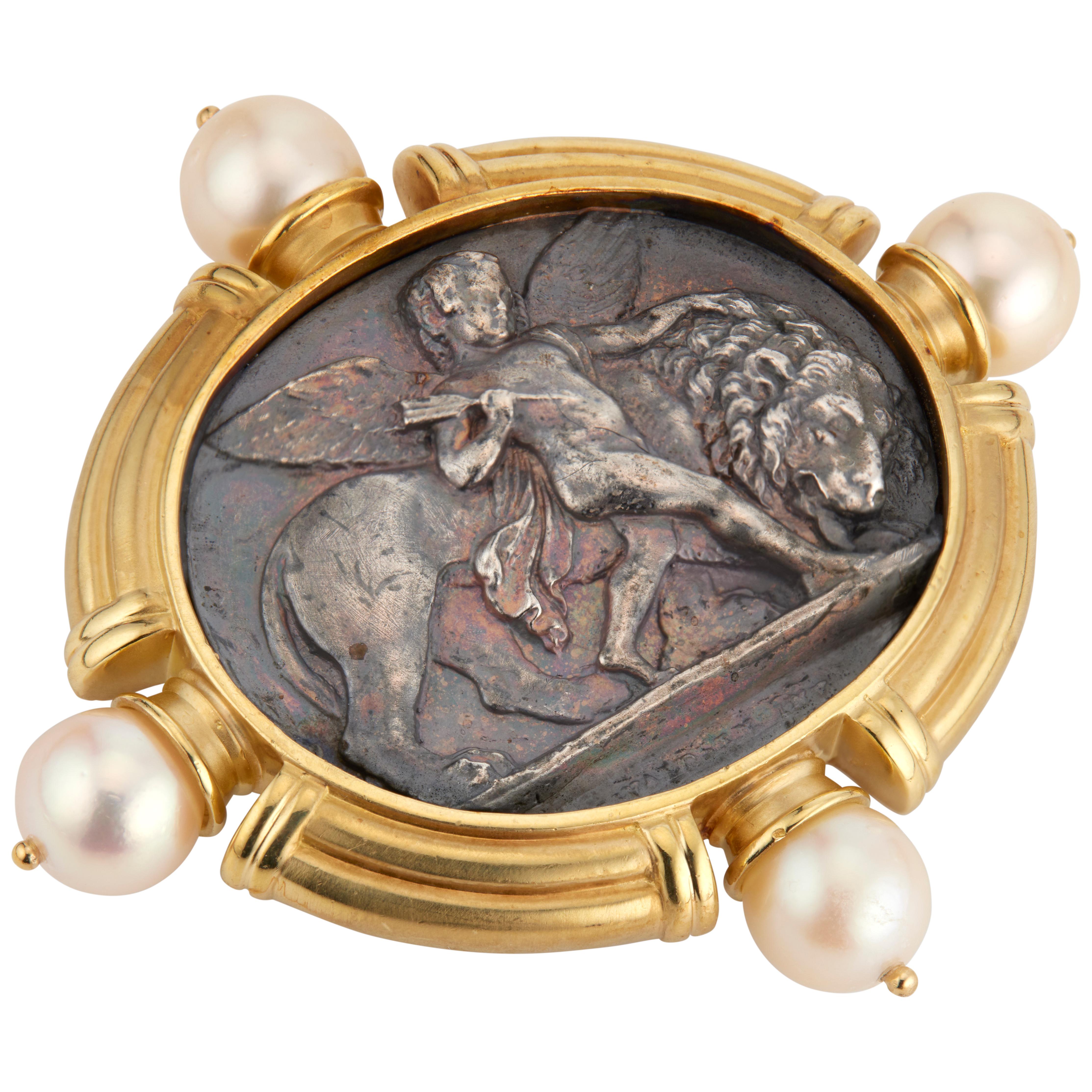 18k yellow gold and silver SeidenGang brooch. 3-D hand crafted silver angel and lion design, with four 9mm South Sea round pearls. 

4 cultured crème/rose color pearls, 9.0mm-9.4mm
18k yellow gold 
Silver 
Stamped: SG 18k
Hallmark: SG