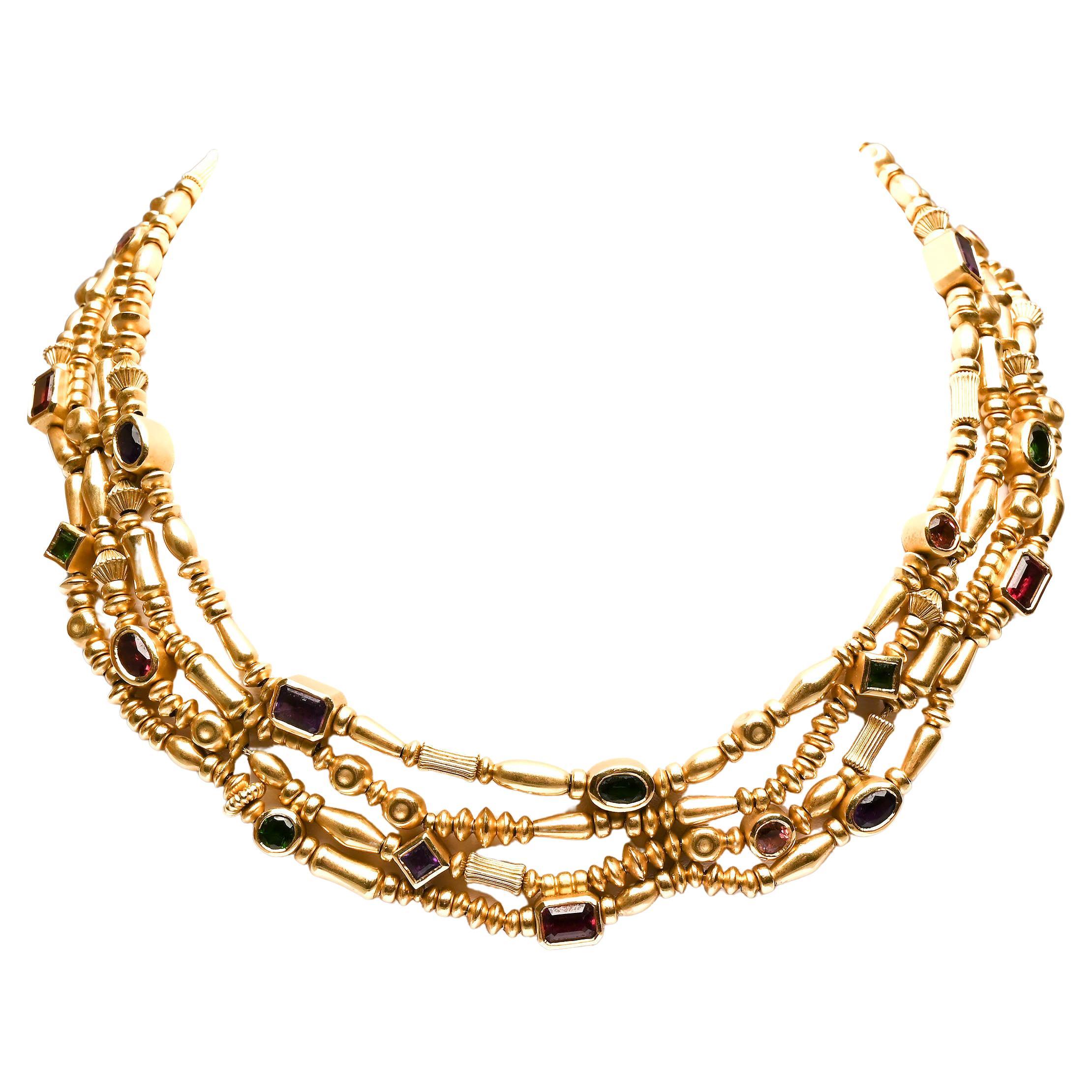 This multistrand gold bead necklace by Seidengang is both sporty and elegant. It consists of four strands of gold beads in a variety of shapes and sizes. Interspersed are round; oval; square and rectangular stones that include: amethyst; citrine;