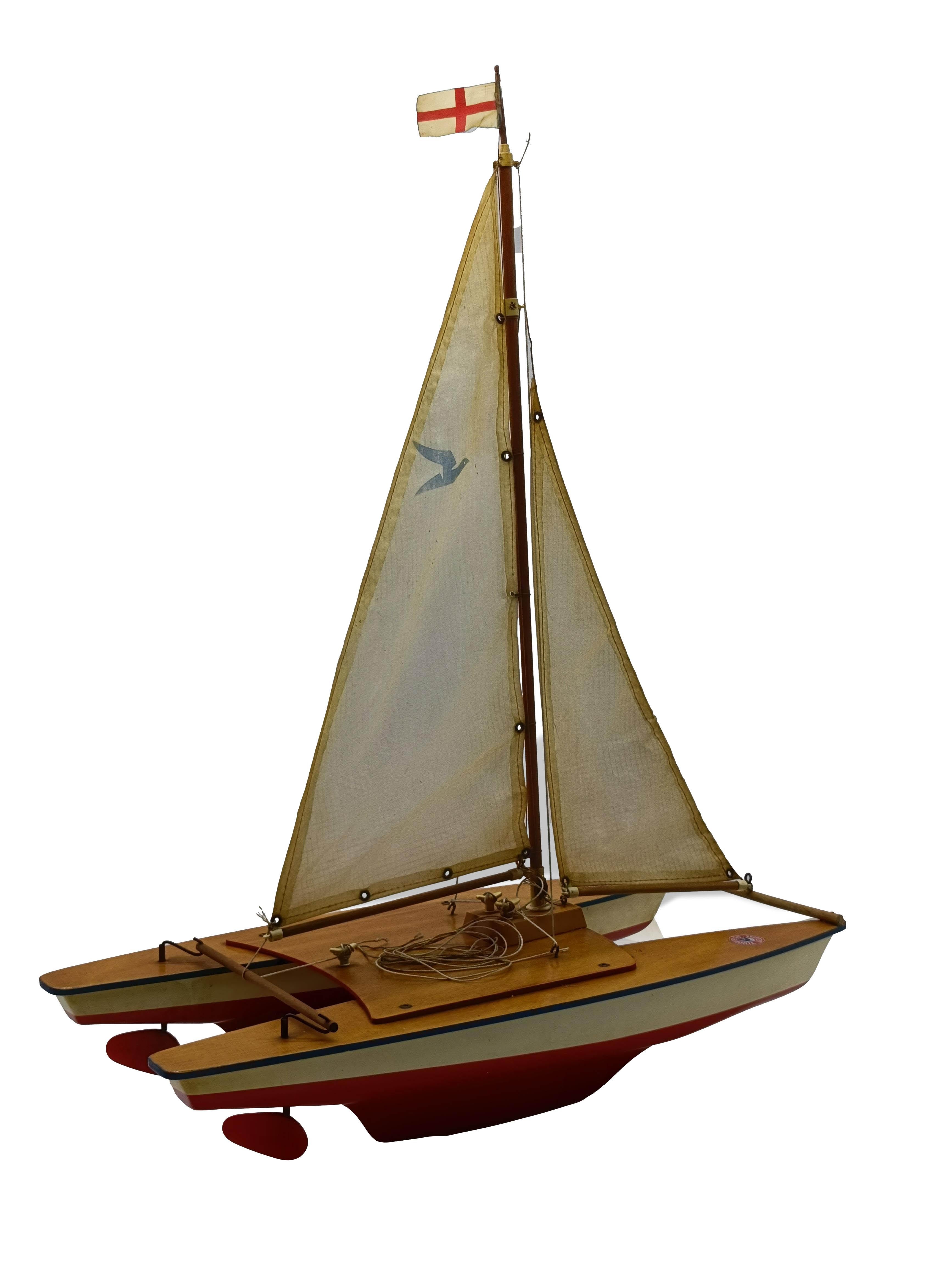 Bateau de collection Seifert produit en Allemagne au début des années 1970. La coque est en plastique sous vide blanc et rouge avec un pont en acajou peint. Ce catamaran est en bon état et a été bien entretenu.
Ce bateau est équipé des voiles