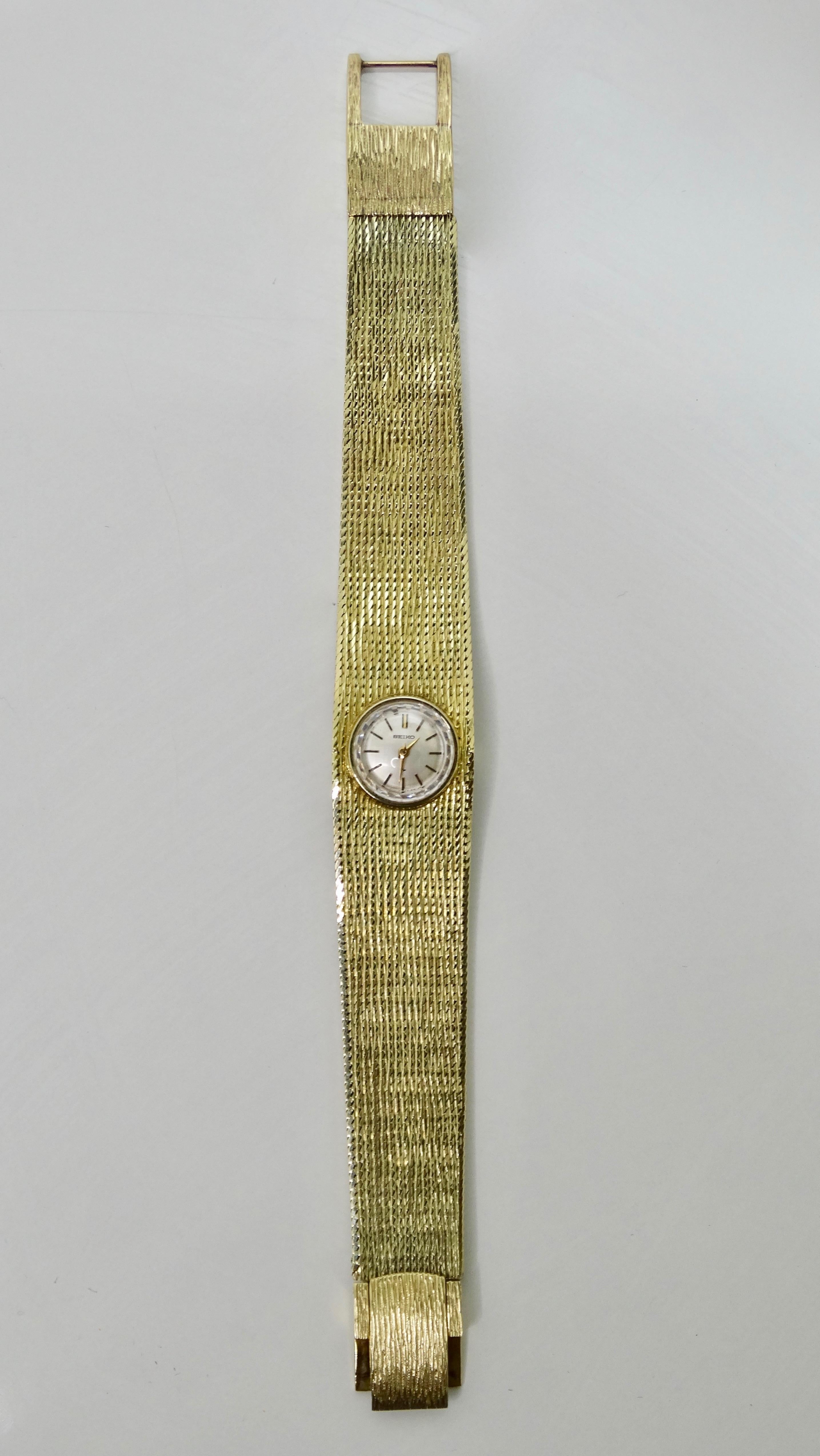 Snag yourself a new timepiece old school style! Circa mid-20th century, this Seiko wrist watch is crafted from 14k Gold and features a 10mm circular face, flexible textured band, and quartz movement. Has a clasp closure and will fit a 7