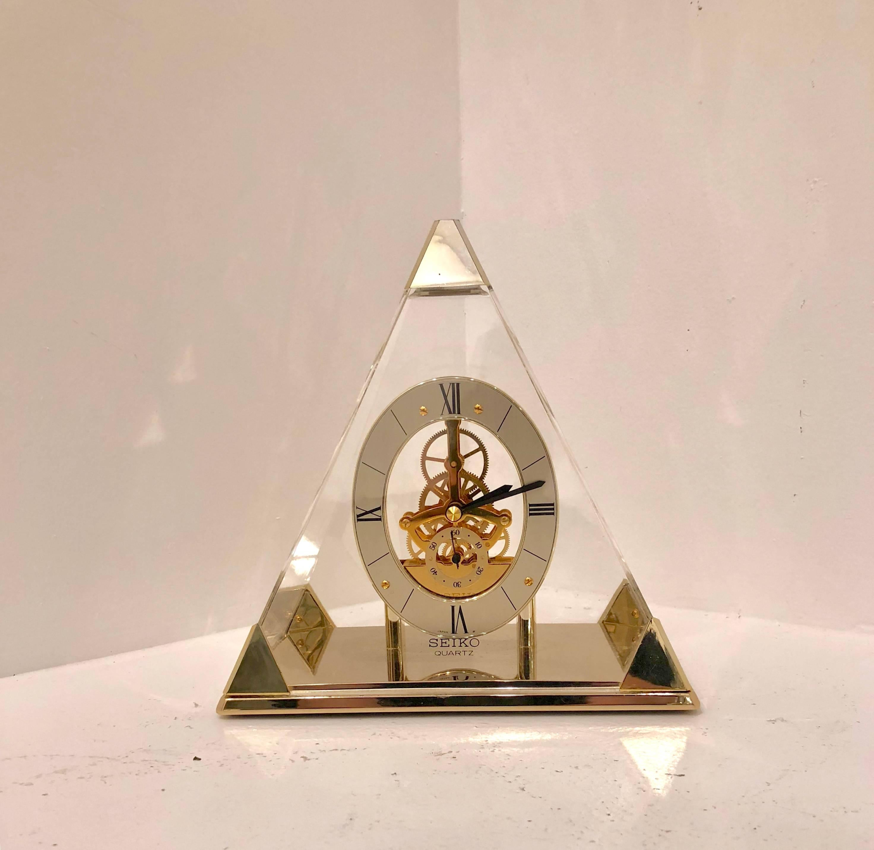 Great design pyramid shape mantel clock, made by the Japanese manufacturer Seiko in great cosmetic and functioning condition, quartz battery operated in Memphis style design with brass accents and Roman numeral numbers.
