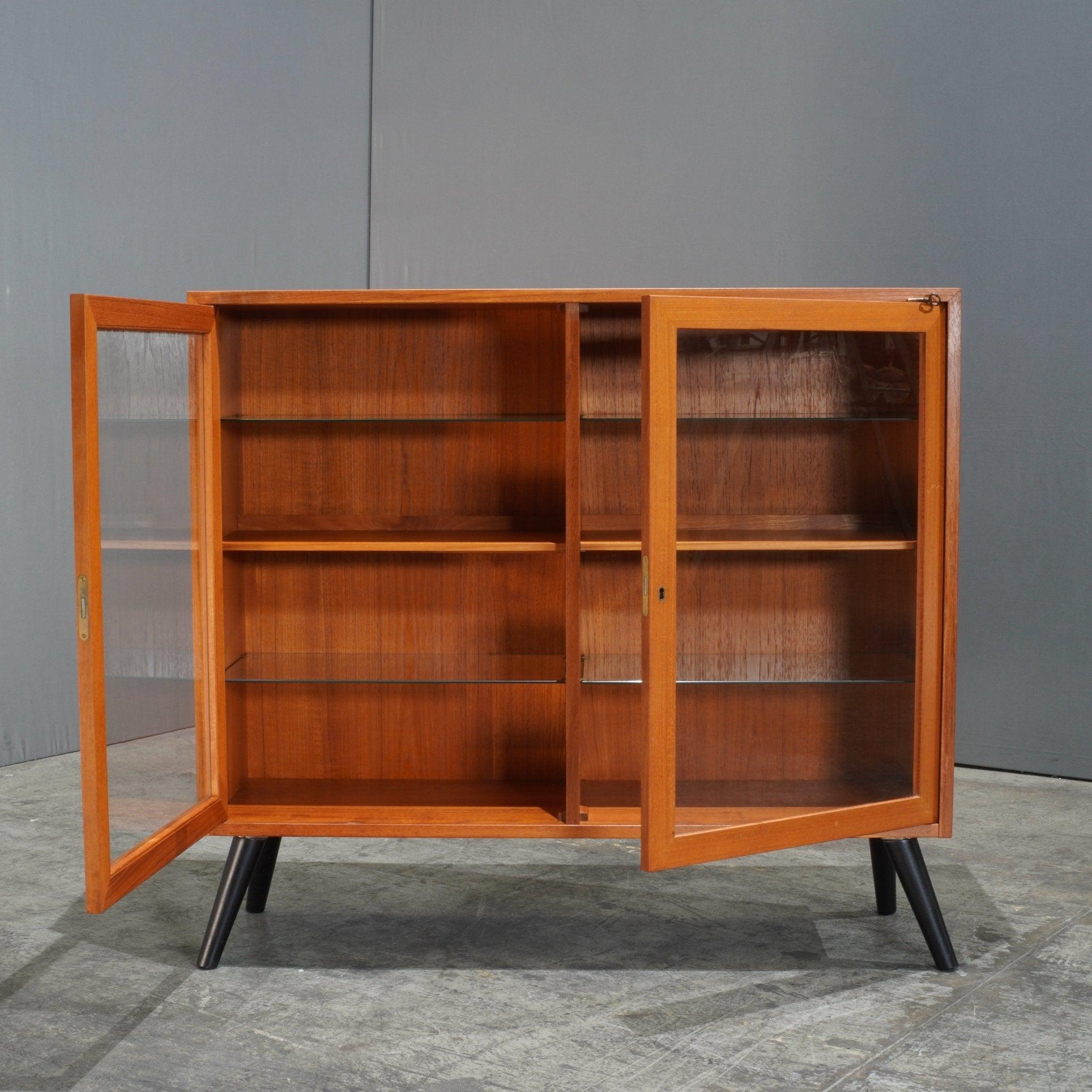 The Sejling Skabe Danish Teak Display Cabinet is a refined embodiment of mid-century Scandinavian design. Crafted in the 1970s from warm, rich teak wood, this cabinet showcases the elegance and functionality synonymous with Danish furniture. Its