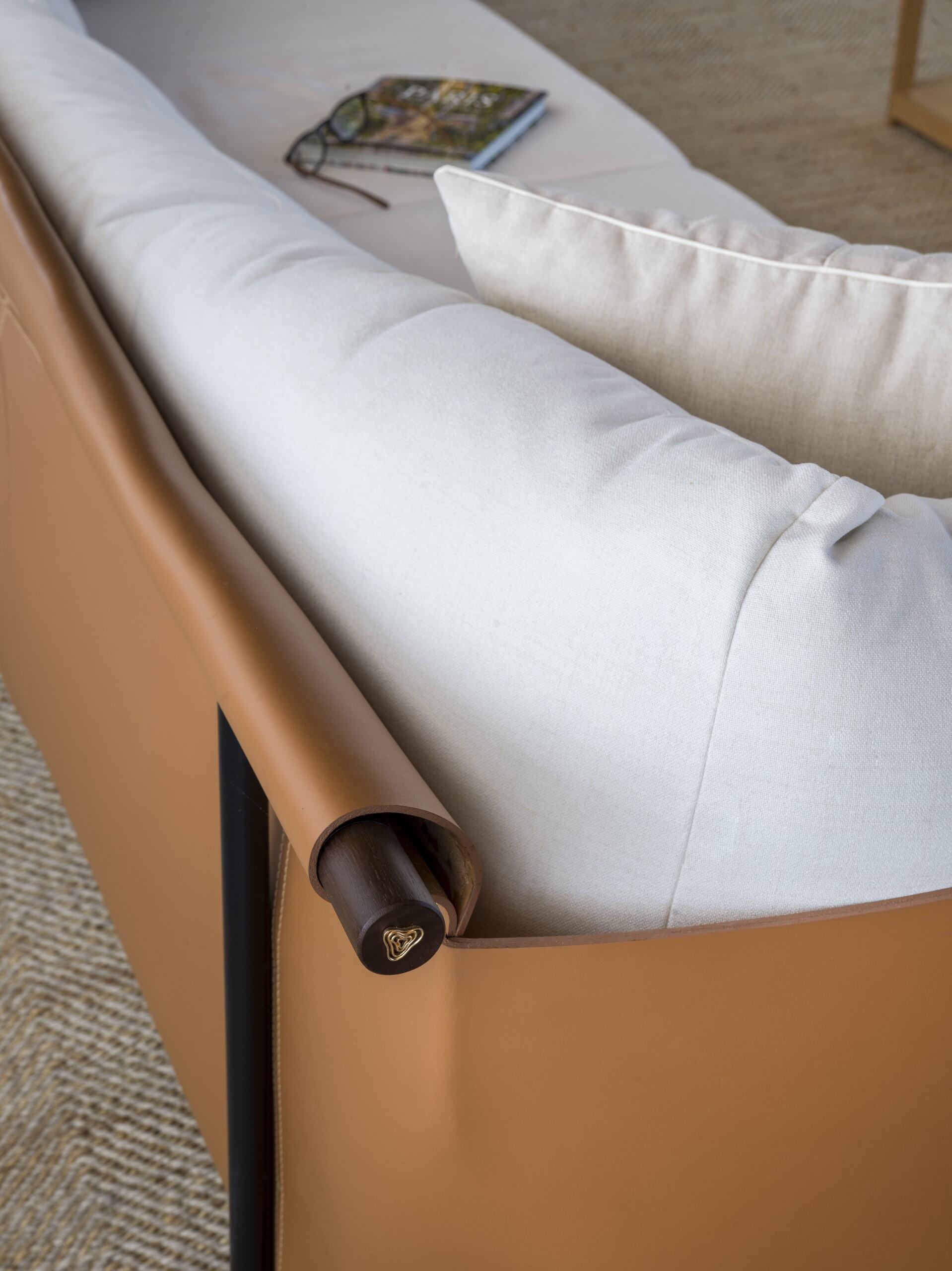 The Sela sofa, designed by Ilse Lang from Studio Faro for +55design, blends minimalist structure with intelligent modularity. Its slim steel frame and lateral supports create a lightweight yet durable foundation, while the vegetable-tanned leather
