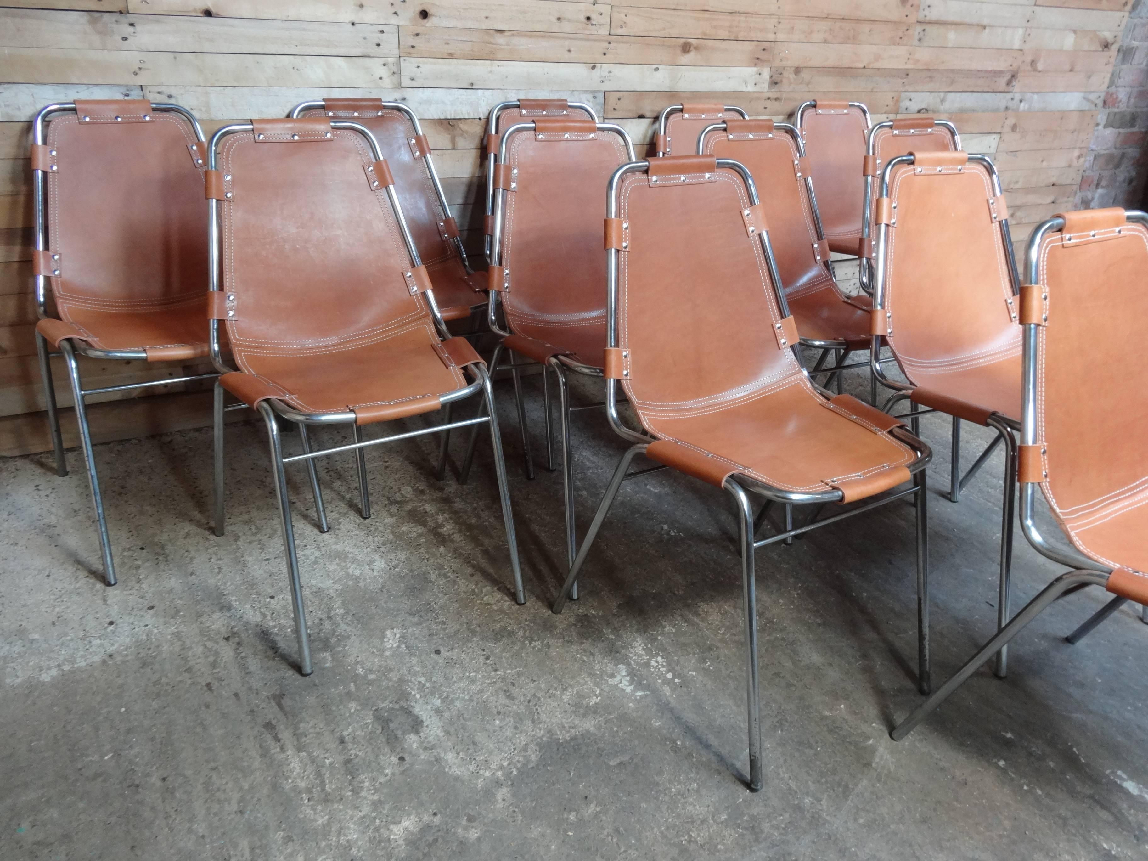 Stunning set of chairs, you will not find another set of 12 chairs like this one on any web site worldwide! Selected by Charlotte Perriand for Les Arcs Ski Resort, circa 1960. Very nice chrome tubular frame with thick brown leather seats, which has