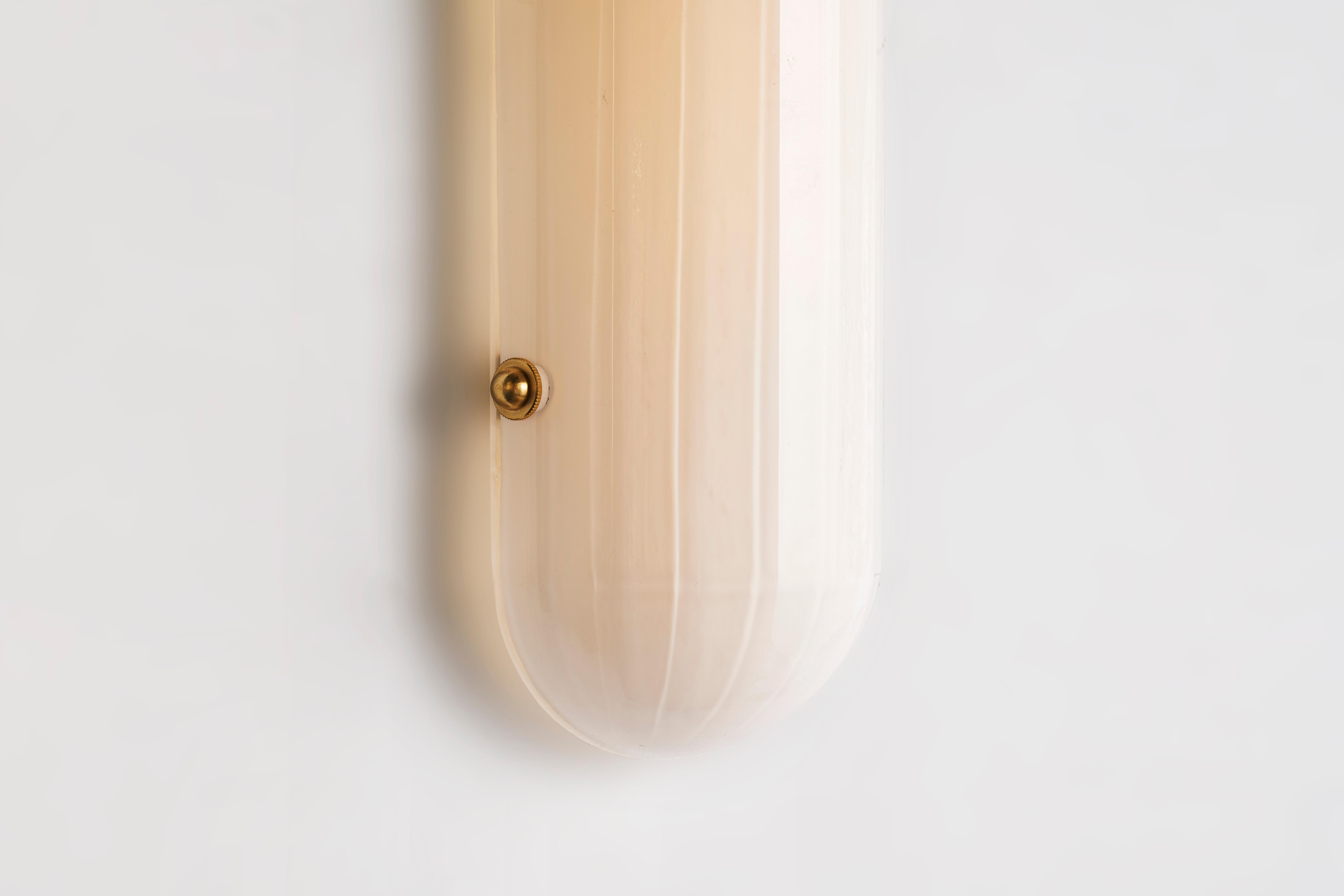 Inspired by Art Moderne, the Selene sconce is part of Bianco light and space, streamline series. Composed of mold blown faceted glass shown in enamel white and brass hardware with LEDs providing a warm directional light maximizing efficiency and