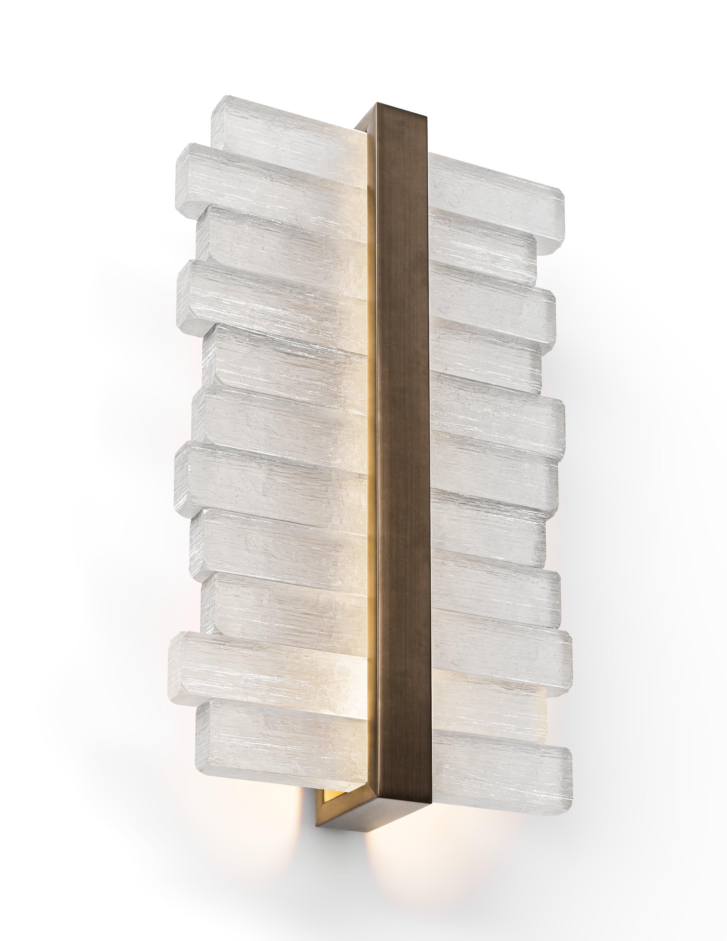 Elegante y arquitectónico, el aplique Selene de Brian Chaaban aporta un refinado sentido del equilibrio y la materialidad a cualquier interior. Un soporte metálico central ancla un cilindro de cristal acabado a mano, emitiendo un suave resplandor