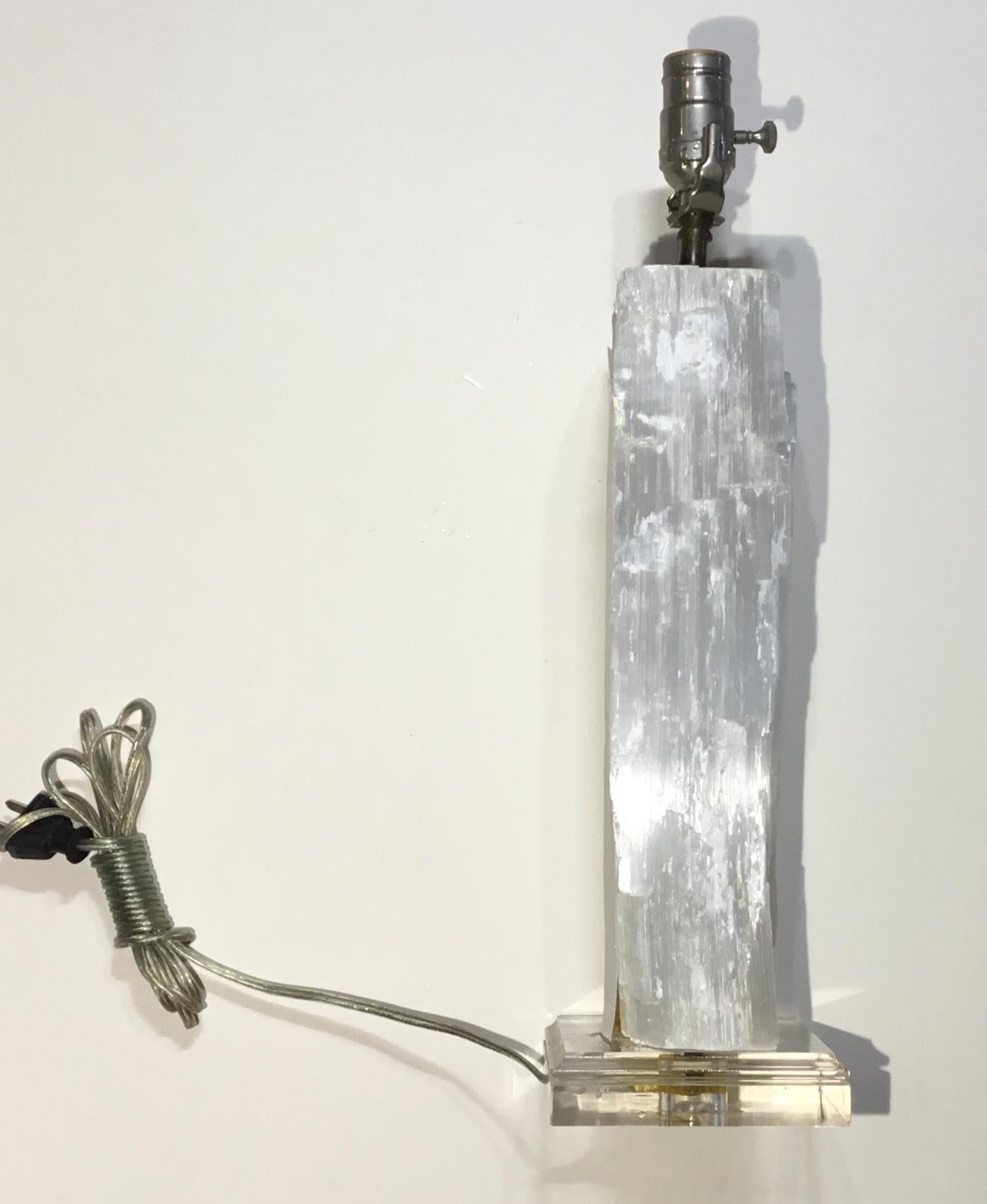 Exceptional table lamp made of selenite crystal stone professionally mounted on a Lucite base .electrified with one 60/watt light 
Ready to use.