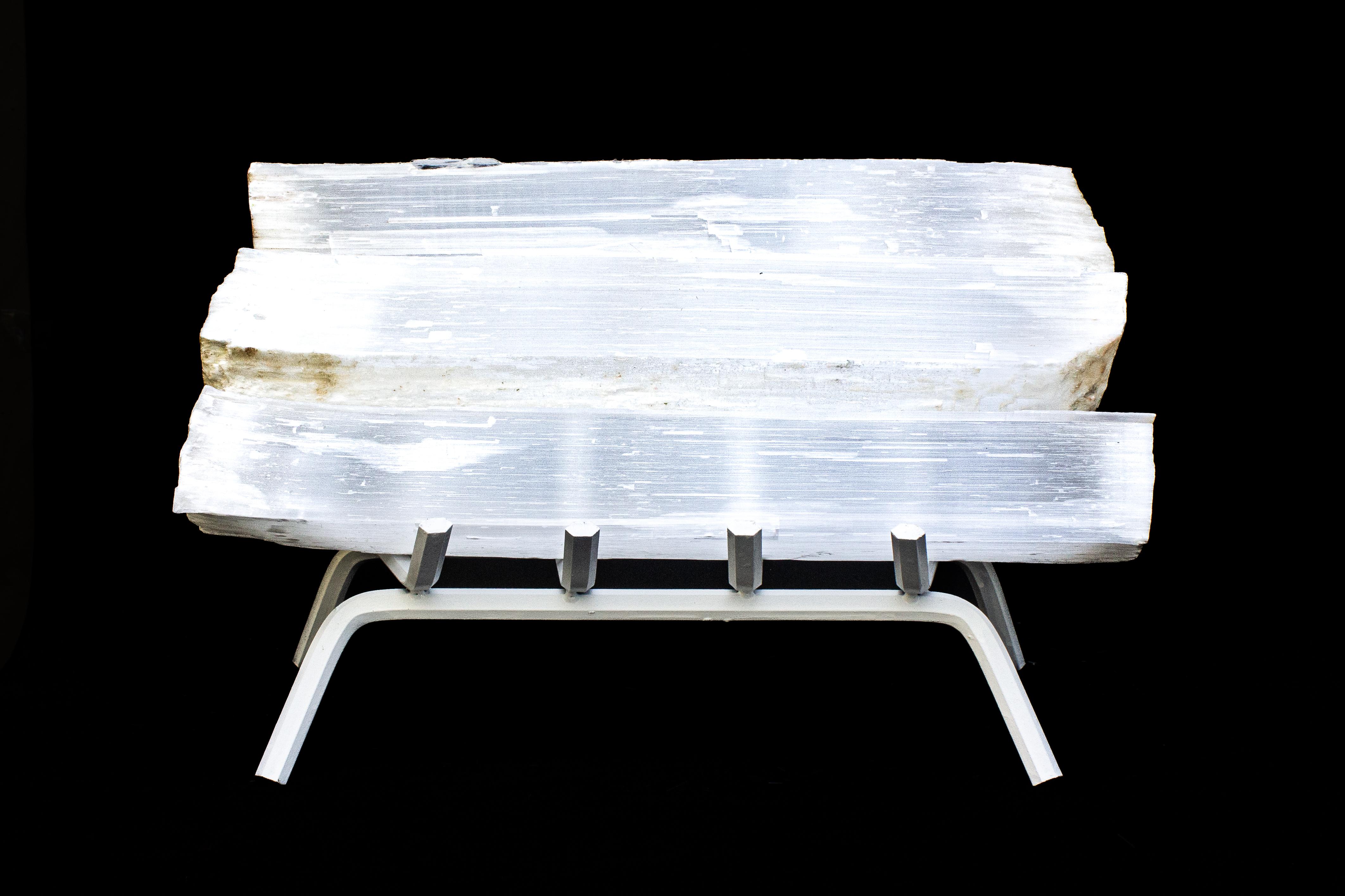 Set of four selenite logs or ruler selenite with a white fireplace grate.

Selenite logs are single, prismatic selenite crystals from Morocco that were formed in extensive beds by the evaporation of ocean brine. This mineral is characterized by a
