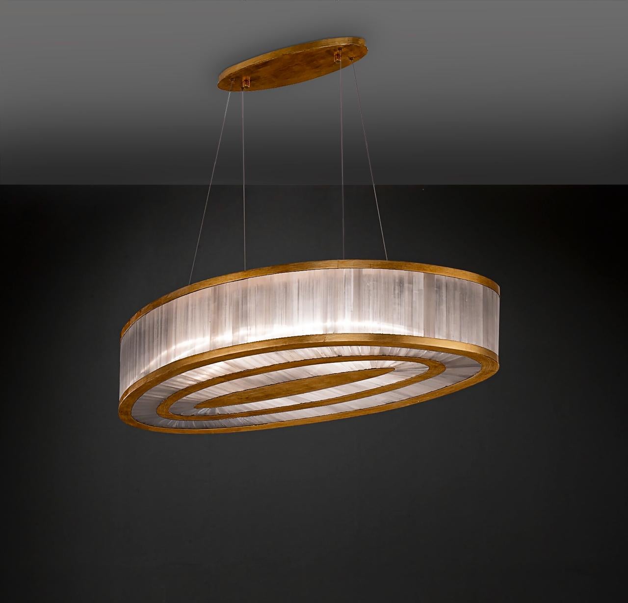 Selenite oval pendant lamp By Aver
Dimensions: D 60 x W 110 x H 21 cm
Materials: Selenite, metal.
Also available: silver leaf, antique silver leaf, gold leaf, brass leaf, copper leaf, pink gold leaf.

Cylindrical pendant with a beautiful manual