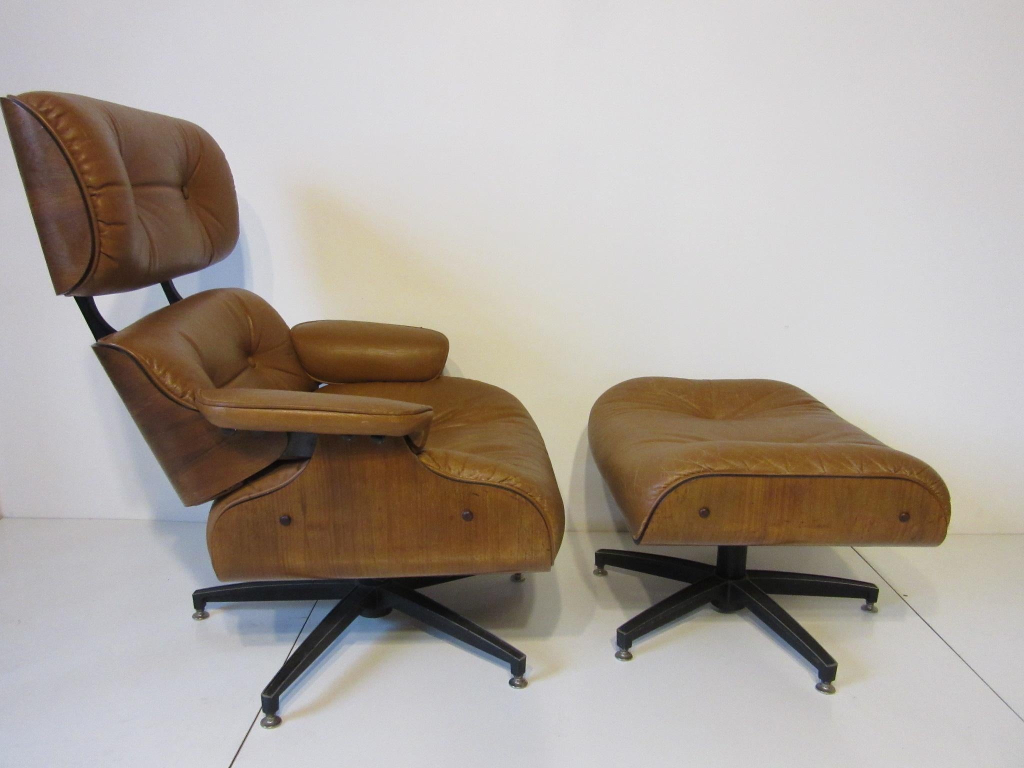 A Herman Miller, Eames styled lounge chair and matching ottoman in a soft saddle colored tufted leather having a slight rocking and a swiveling mechanism for comfort . Wrapped in a medium toned walnut frame with five star cast aluminum base