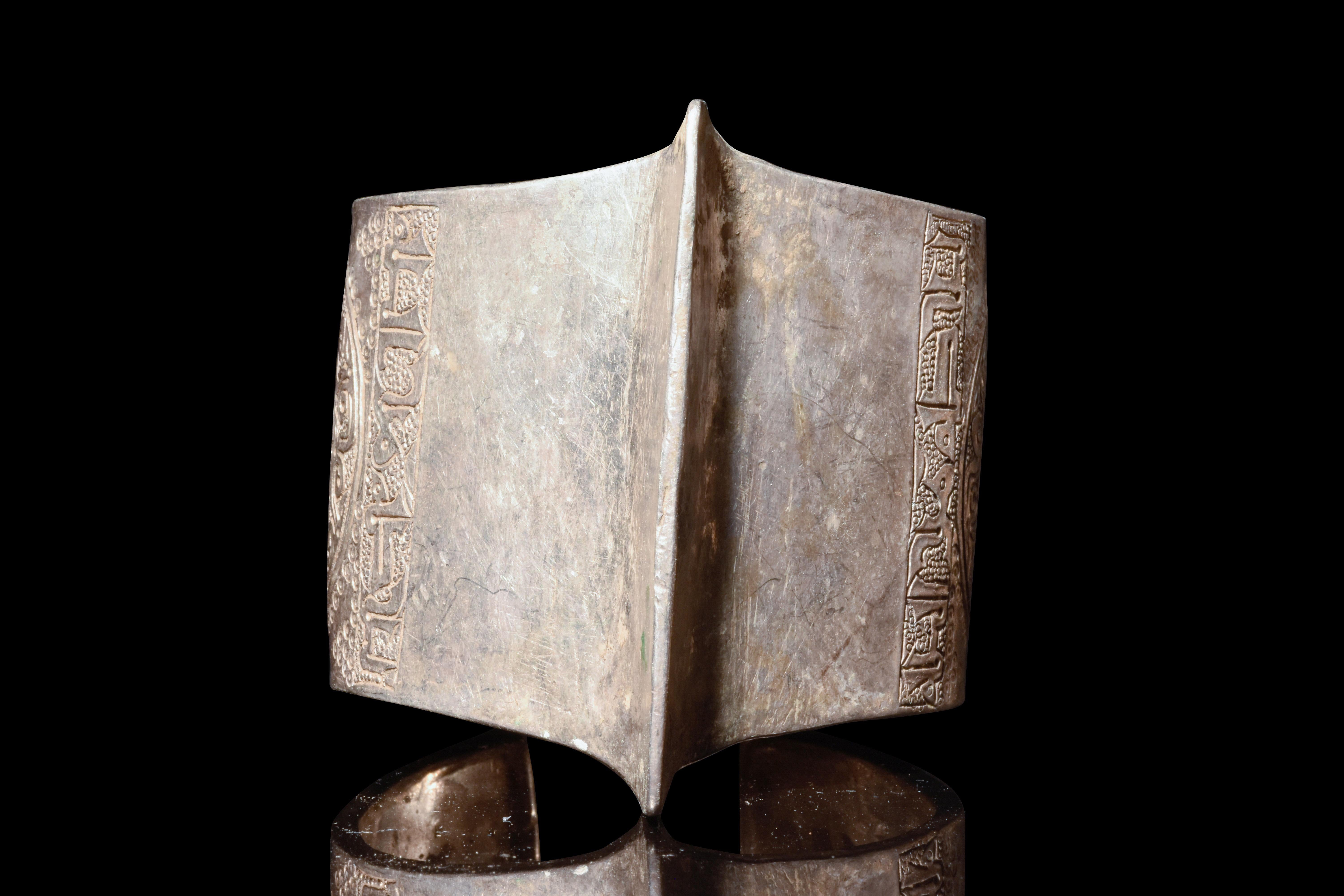 Ein silberner seldschukischer Penannular-Armreif mit einem Mittelgrat und runden Rosettenmustern. In der islamischen Kunst symbolisieren diese Muster die göttliche Schöpfung und die ewige Natur, wobei die Arabesken die Unendlichkeit und die